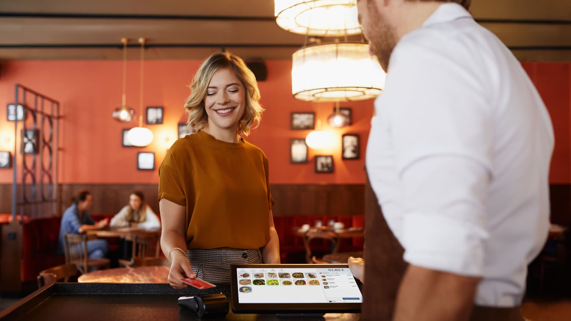 Eine Frau bezahlt in einem Restaurant an der Theke