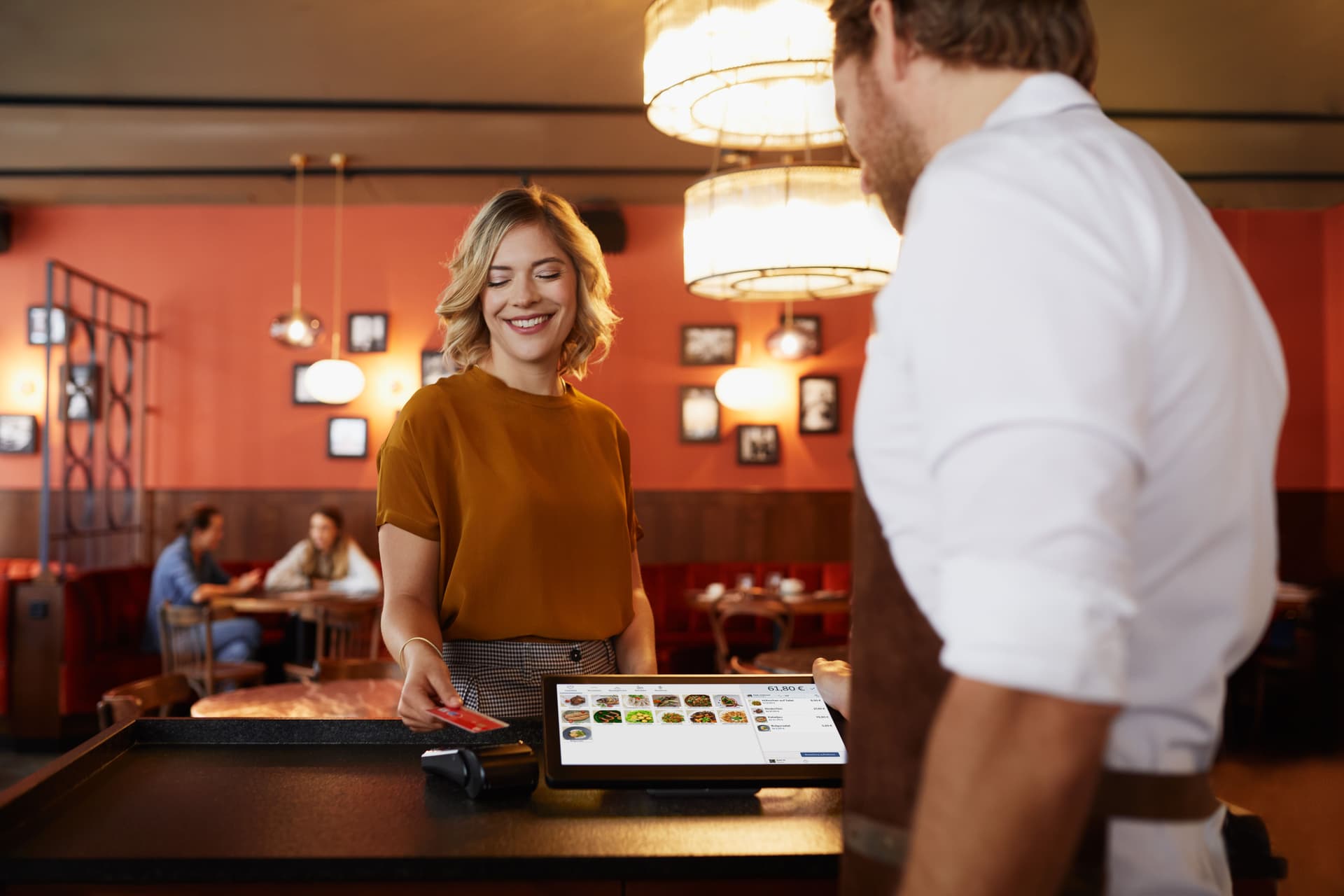 Eine Frau bezahlt in einem Restaurant an der Theke