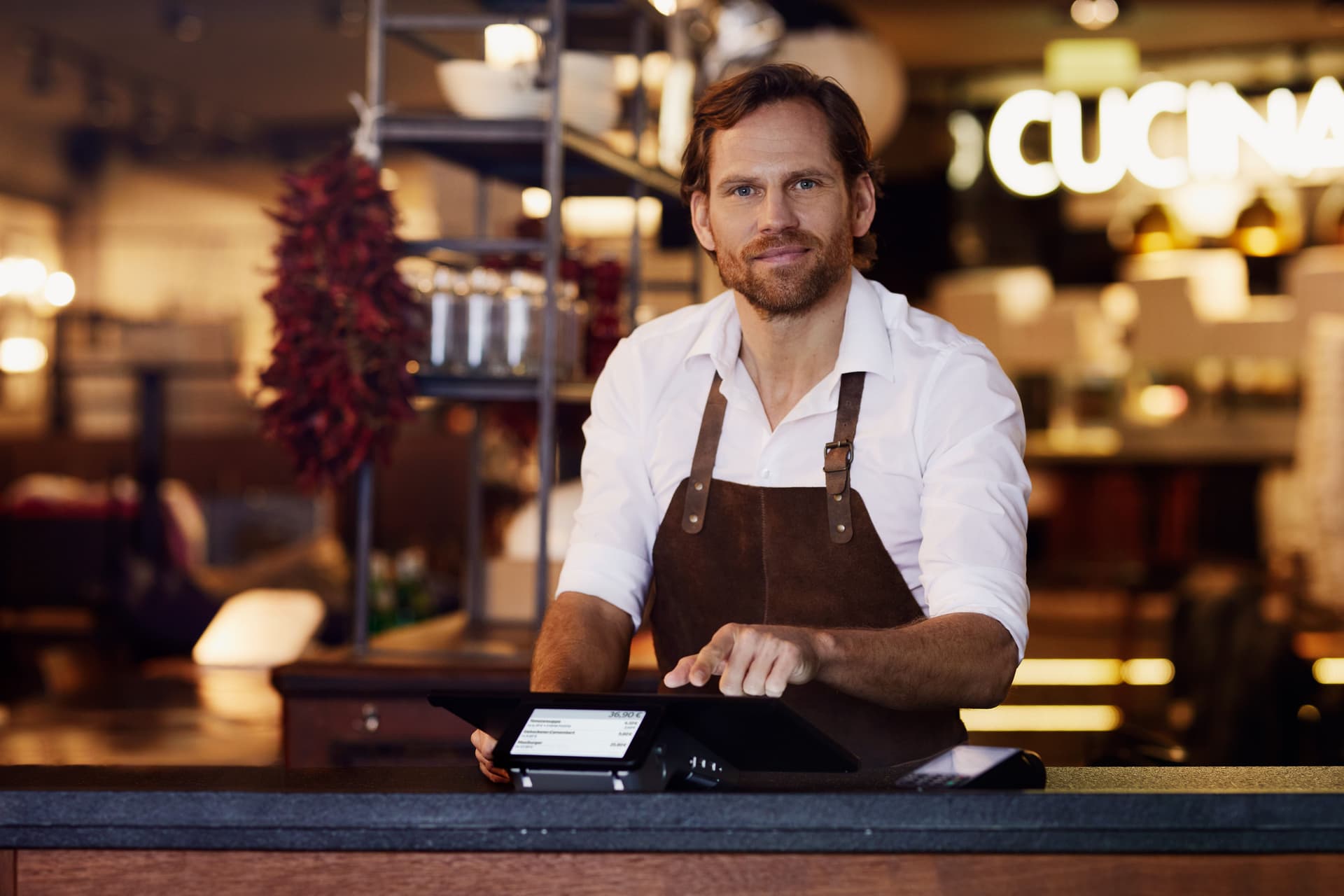 Ein Mann steht in einem Restaurant an einem Kassensystem