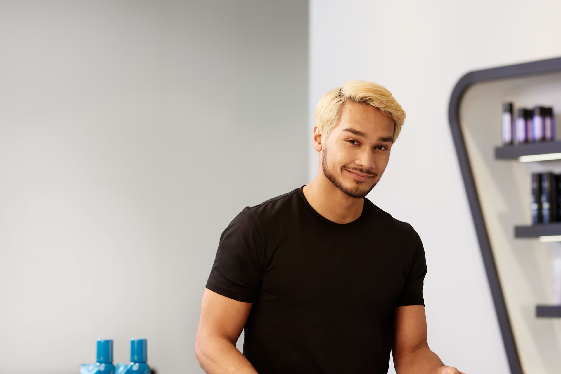 Ein Friseur steht in einem Friseursalon an der Kasse.