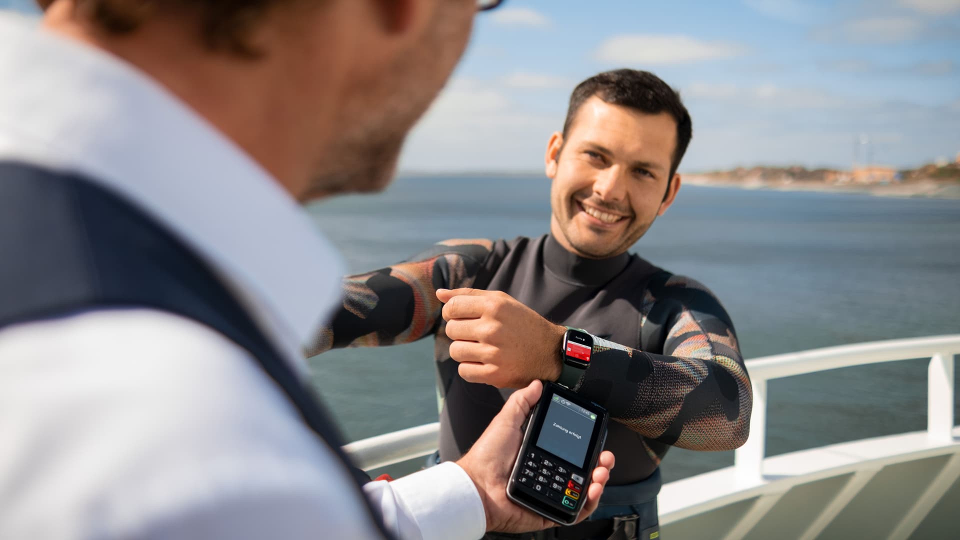 Ein Mann bezahlt auf einem Schiff mit seiner Apple-Watch