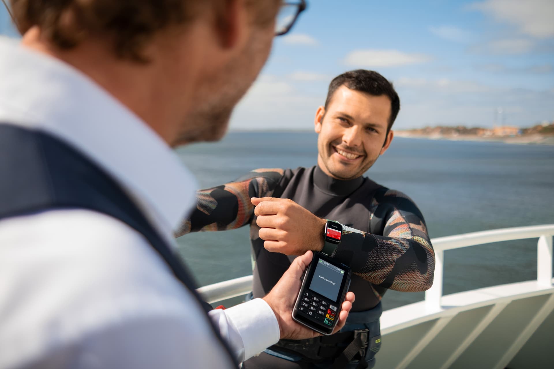 Ein Mann bezahlt auf einem Schiff mit seiner Apple-Watch