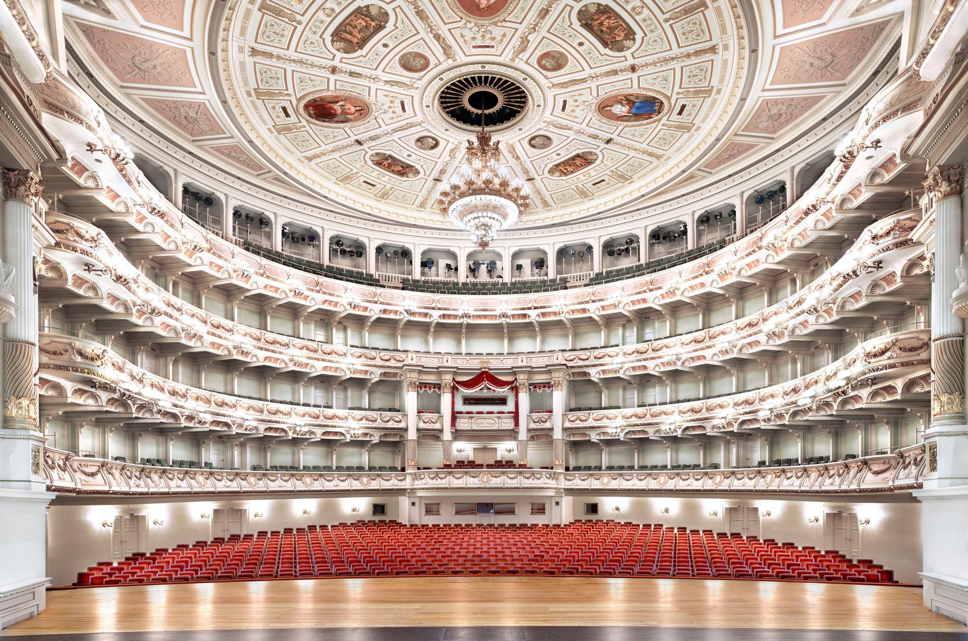 Fotografie einer Opernbühne mit Blick auf die menschenleeren Zuschauerränge.