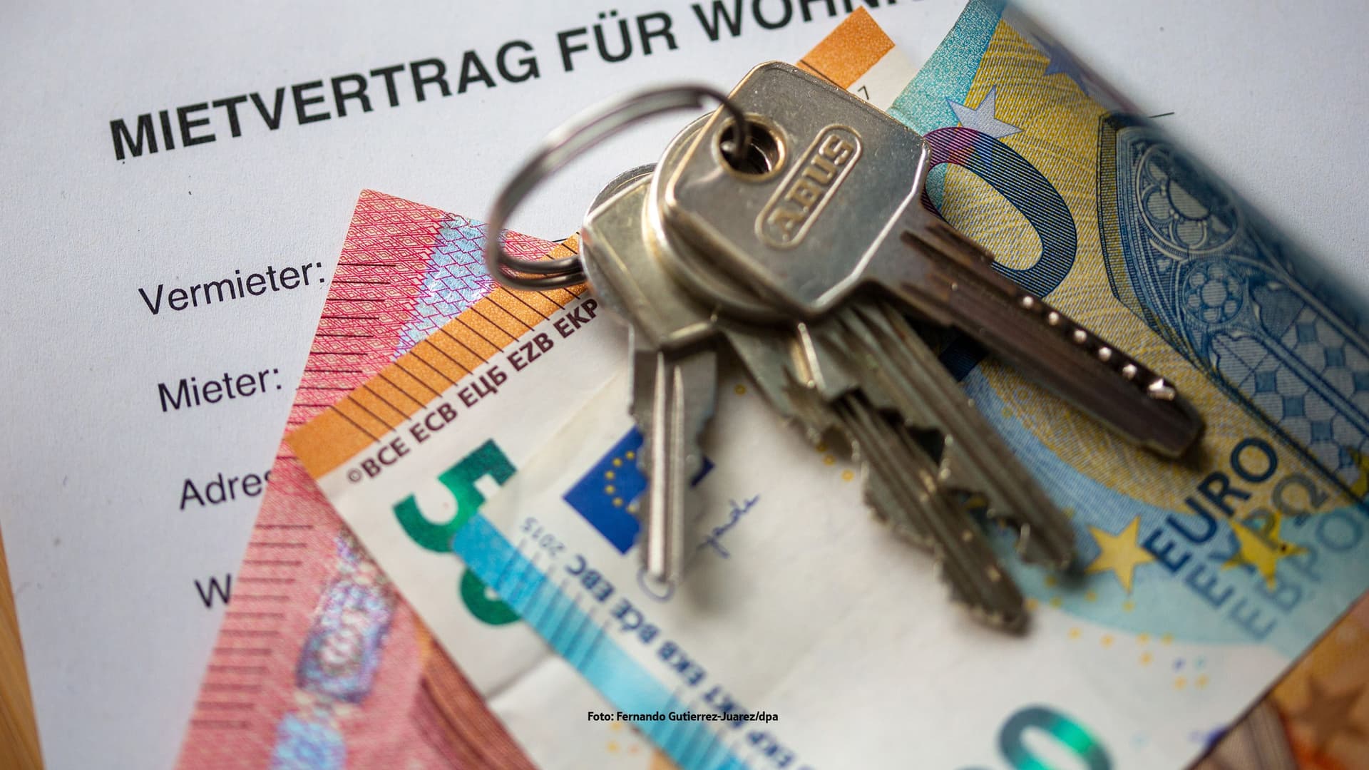 Geld und Schlüssel liegen auf einem Mietvertrag