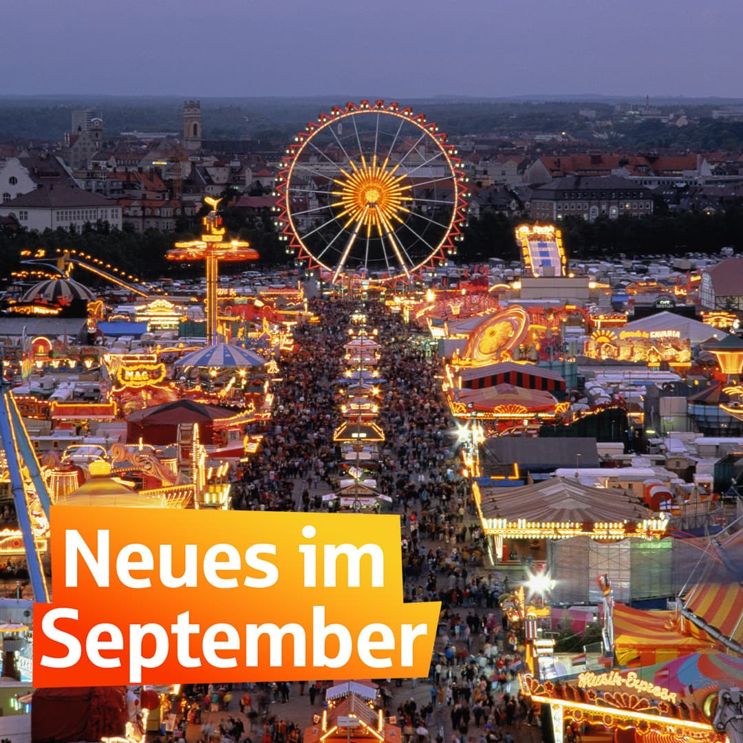Blick von oben auf das beleuchtete Oktoberfest in München mit Riesenrad, Fahrgeschäften und Menschenmengen bei Abenddämmerung. Text „Neues im September"