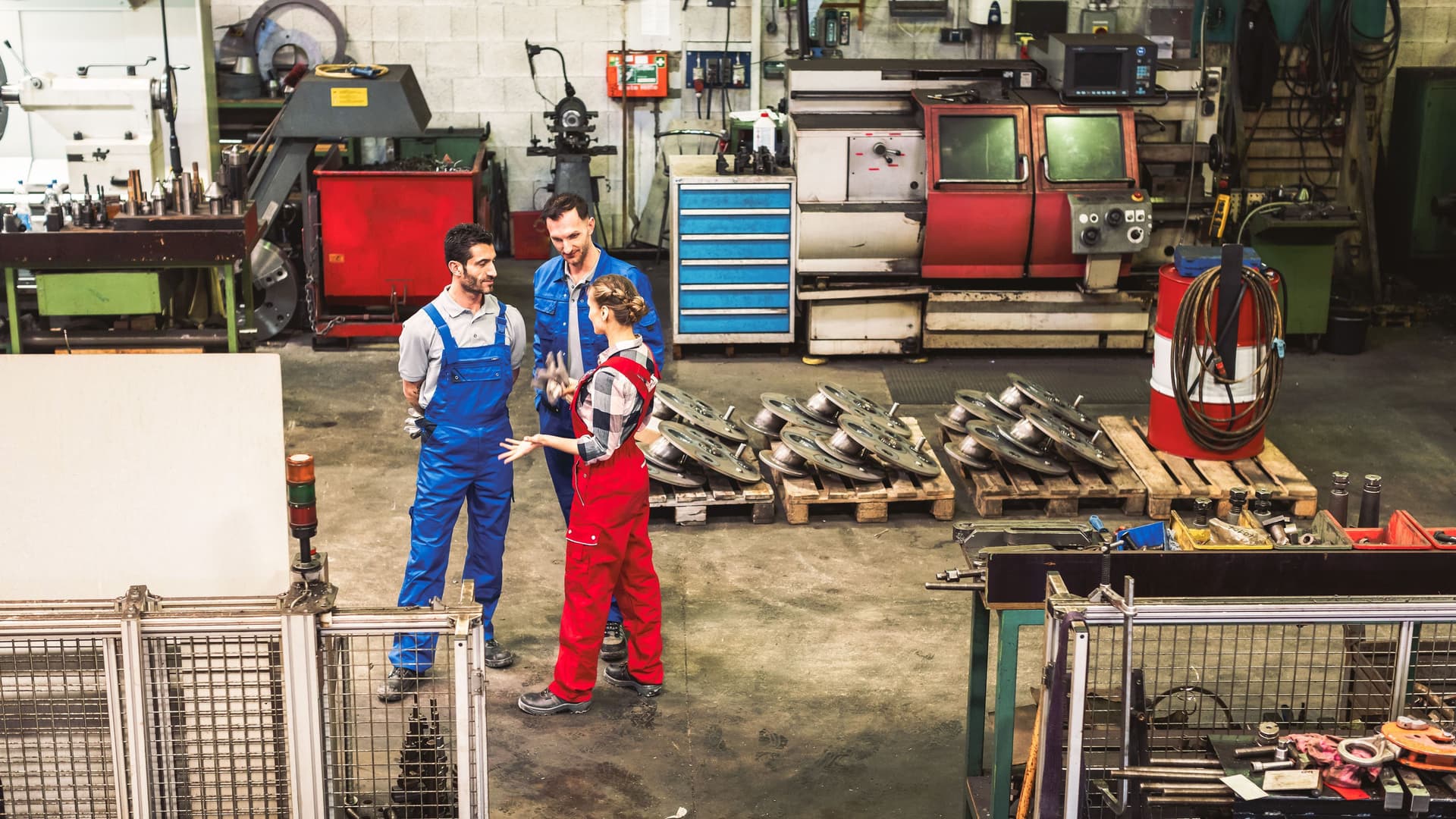 Arbeiter in der Fabrikhalle im Gespräch