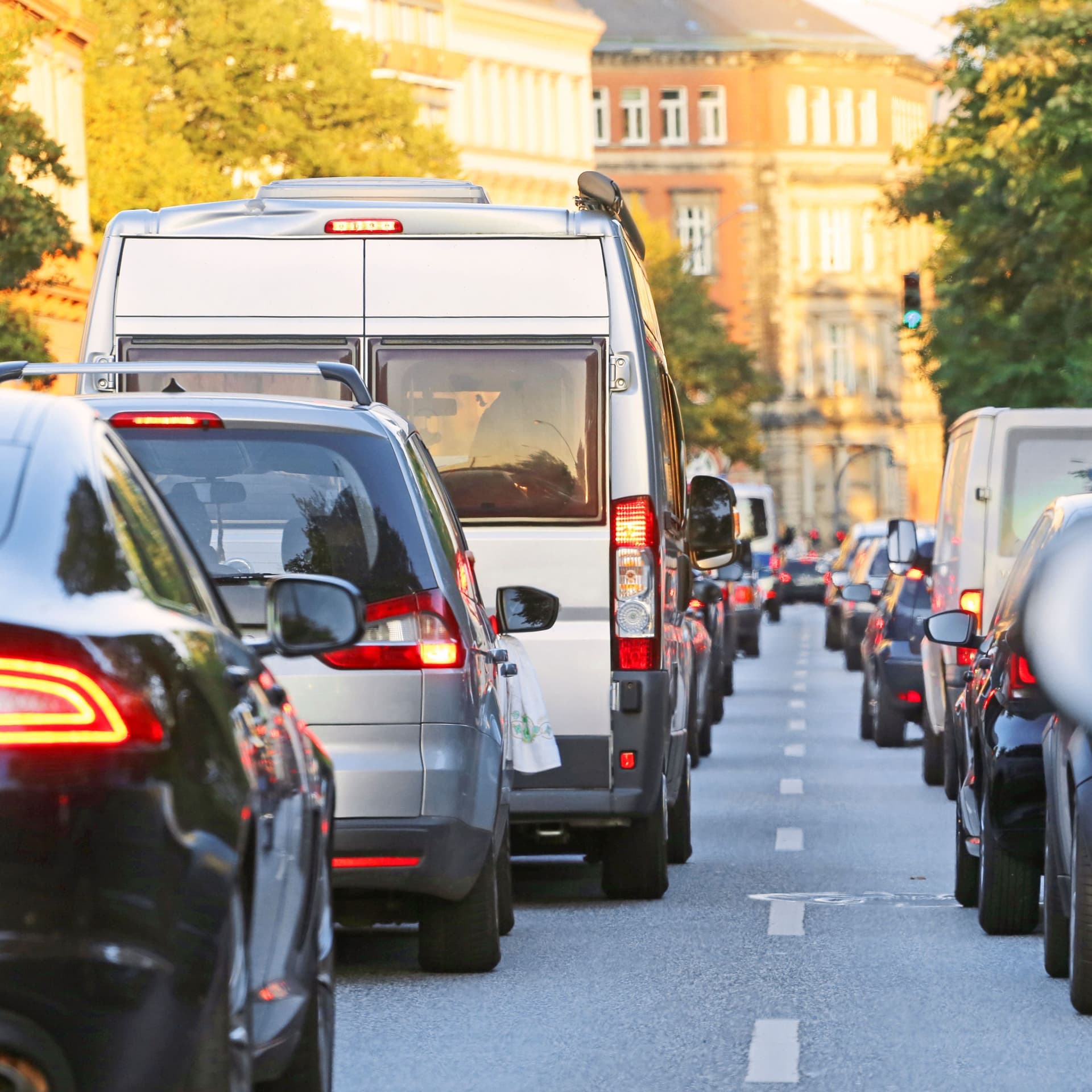 Zwei Reihen von Autos stehen im Stau. Die Rücklichter leuchten rot.