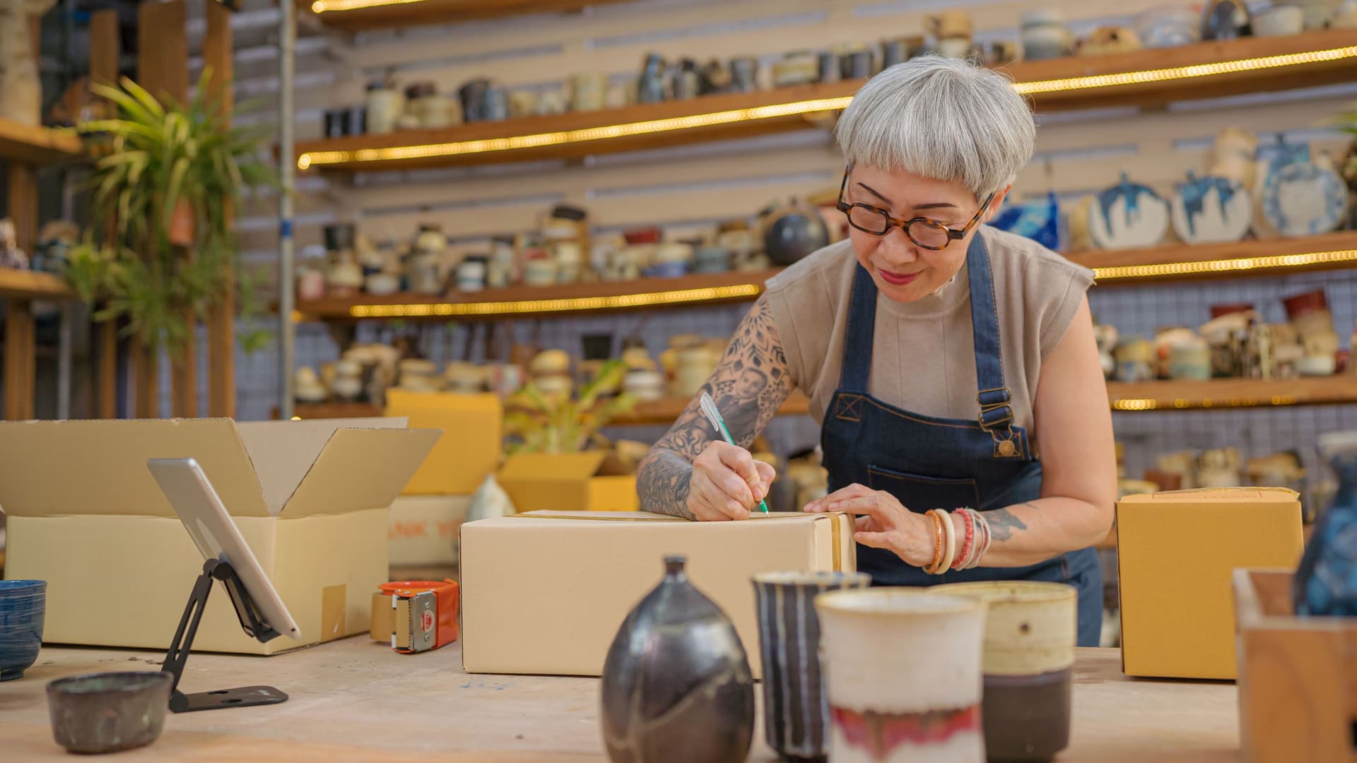 Eine Künstlerin verpackt Keramik-Produkte in ihrem Atelier.