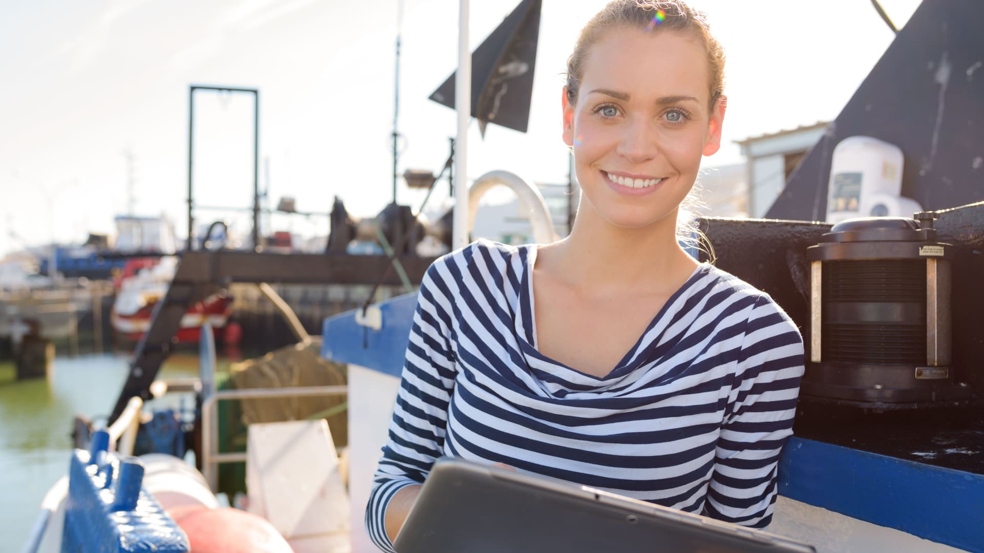 Junge Frau auf Boot mit Tablet