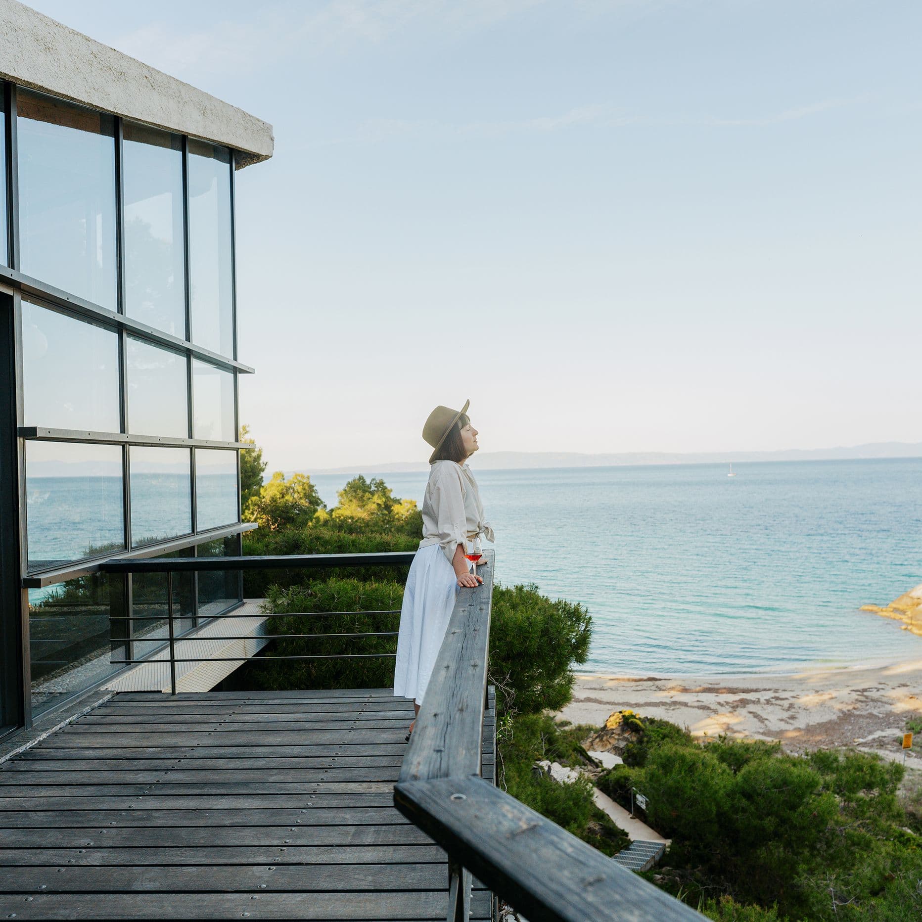 frau-steht-auf-terasse-mit-wein-GI-2250696337-4000kb-original