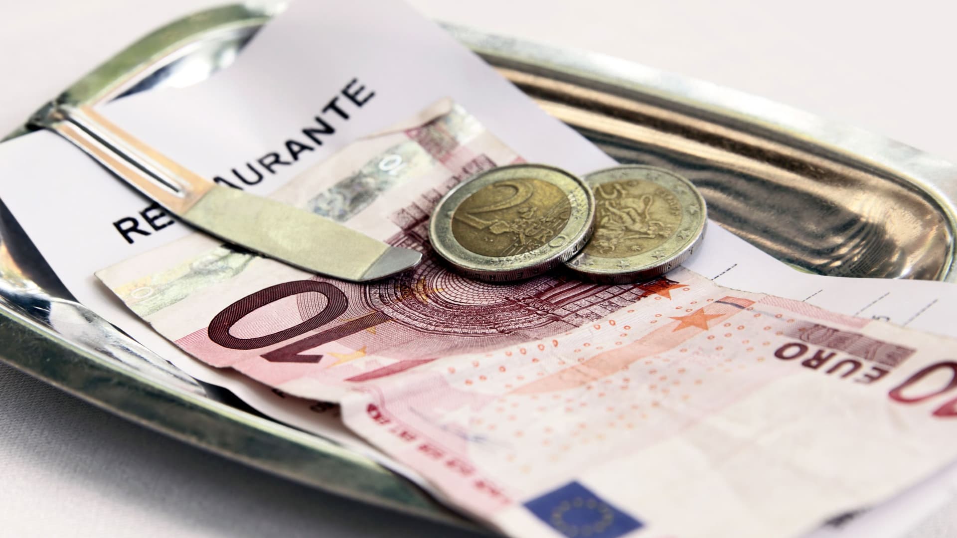 Bargeld liegt auf Restaurant Rechnung in einem Metallbehälter.