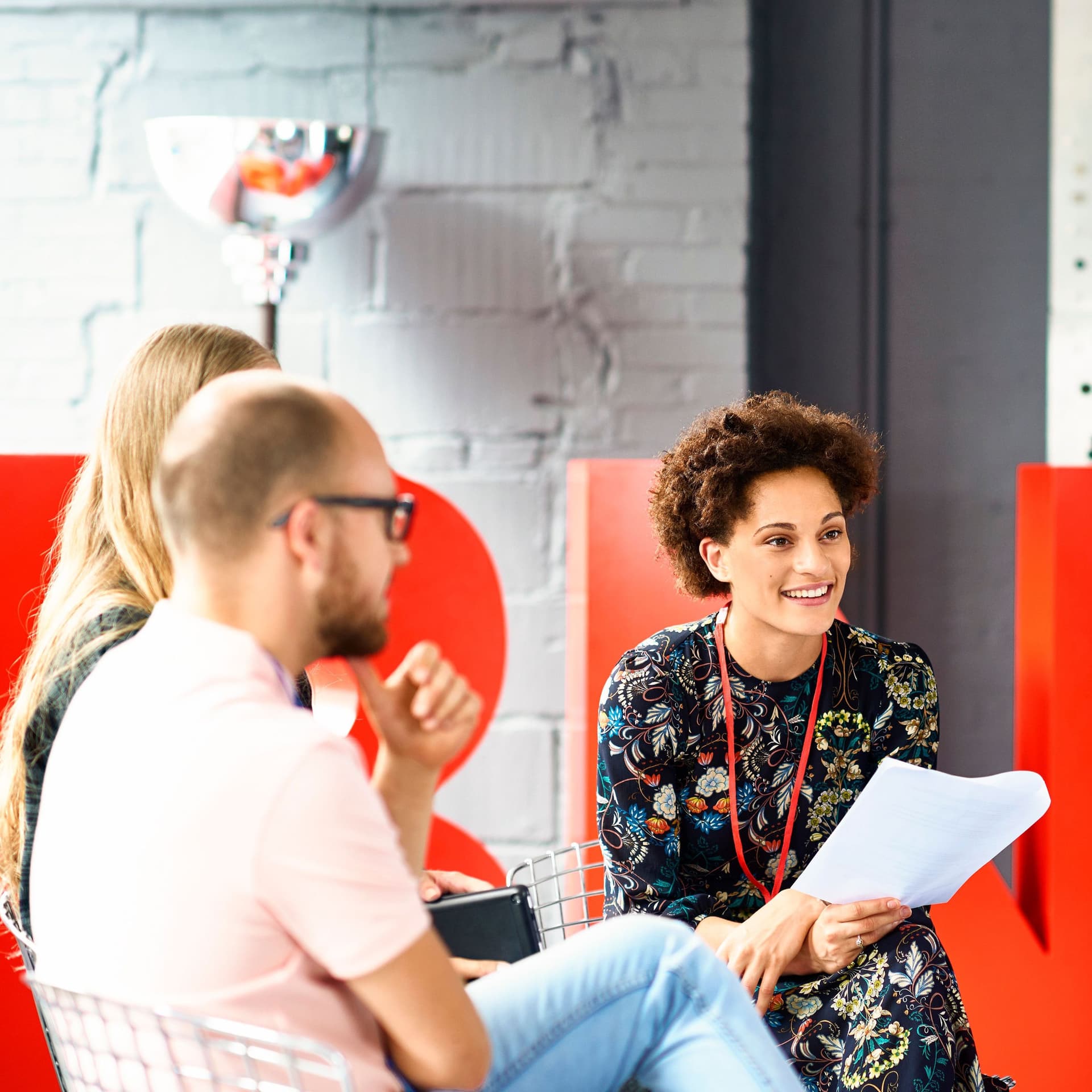 Gemischte Gruppe die eine Besprechung in einen Büro hat.