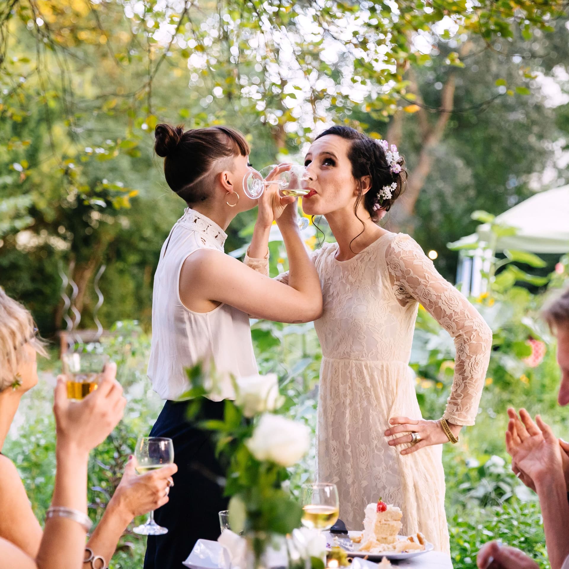 Frisch verheiratete Eheleute trinken mit Freunden auf ihre Hochzeit