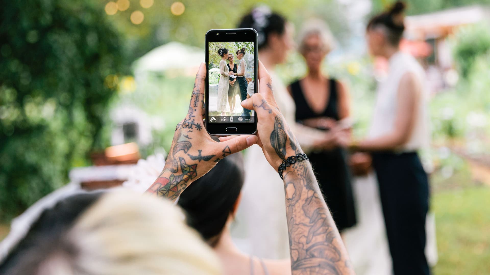 Tätowierte Frau macht ein Hochzeitsfoto mit dem Smartphone