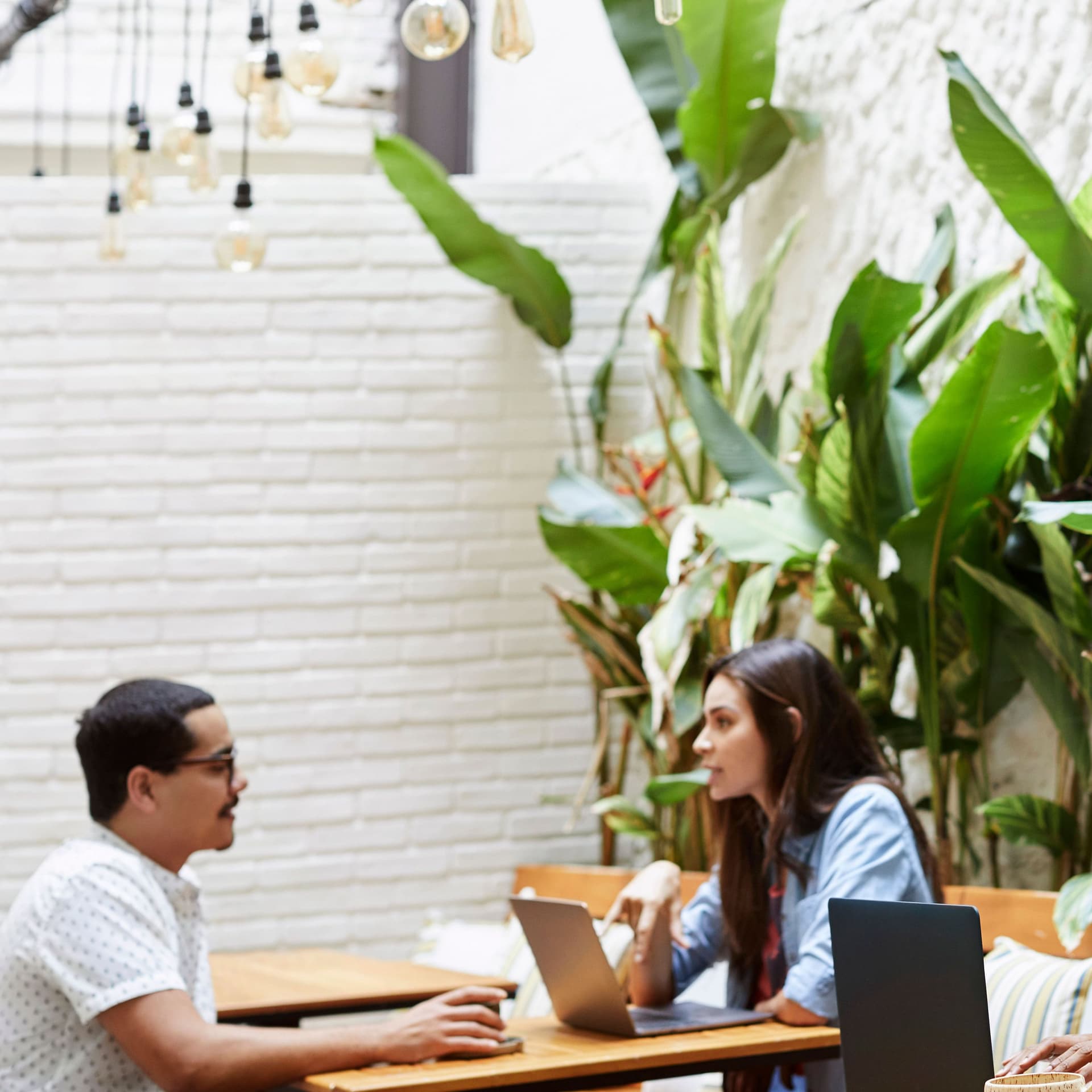 Verschiedene Leute sitzen im Cafe zusammen mit Laptops