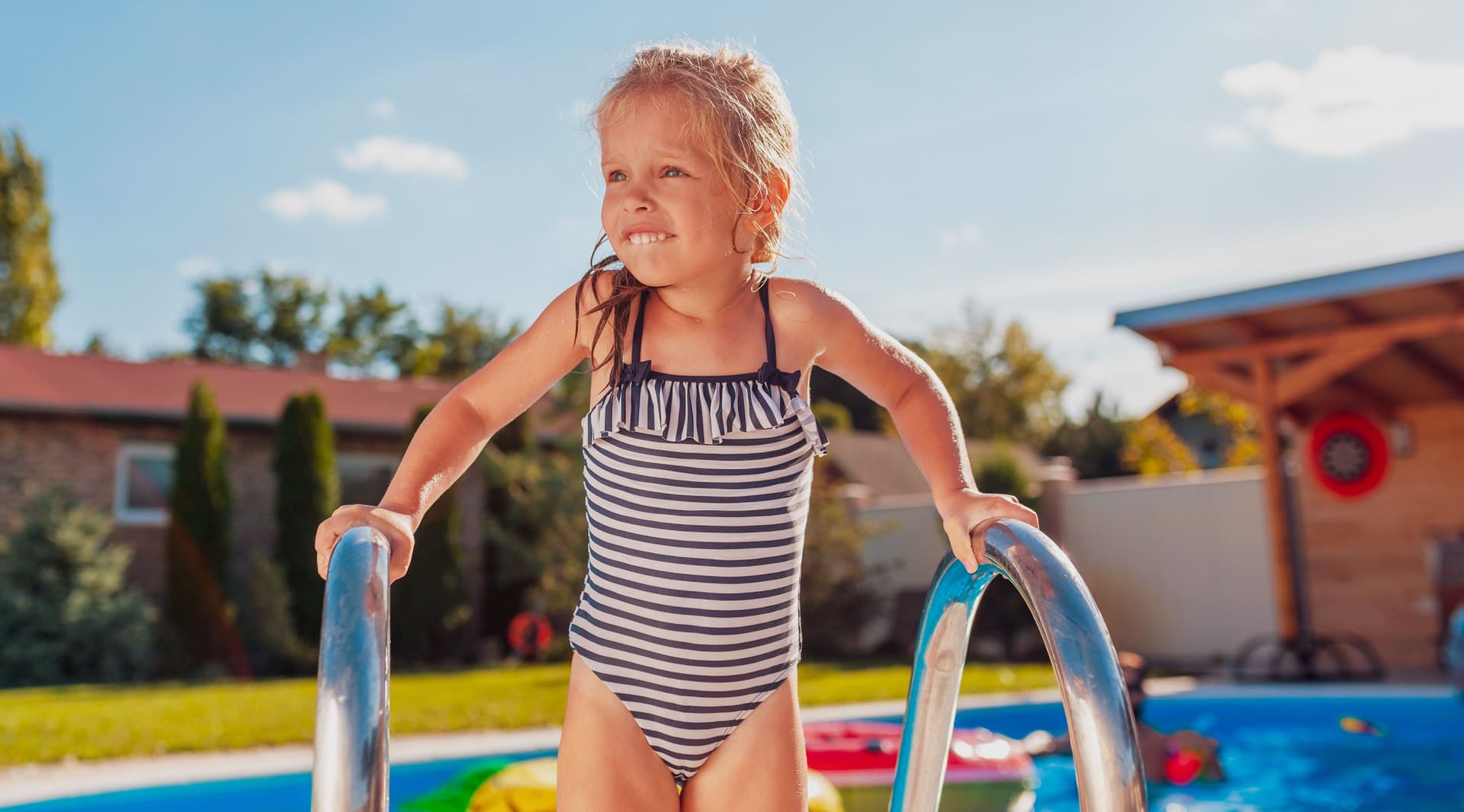 Kleines Mädchen, das aus dem Swimmingpool herauskommt