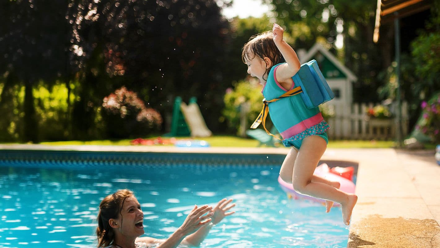 Kleines Mädchen springt in Pool