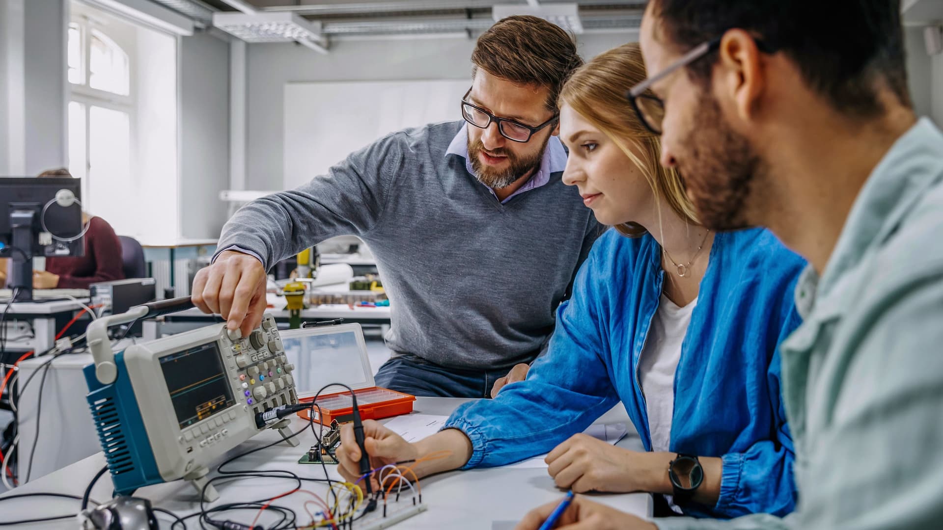 Universitätslehrer instruiert Studenten an elektronischen Geräten