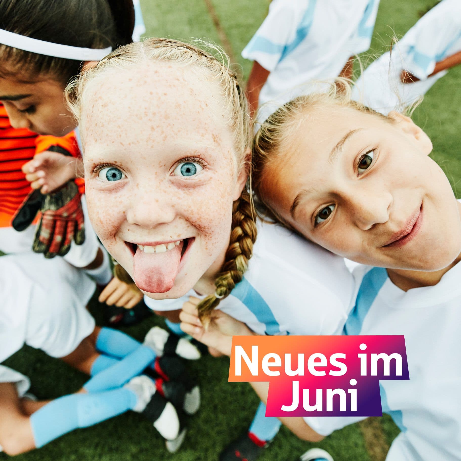 Zwei Mädchen im Fussballoutfit schauen in die Kamera. Ein Mädchen streckt die Zunge raus.