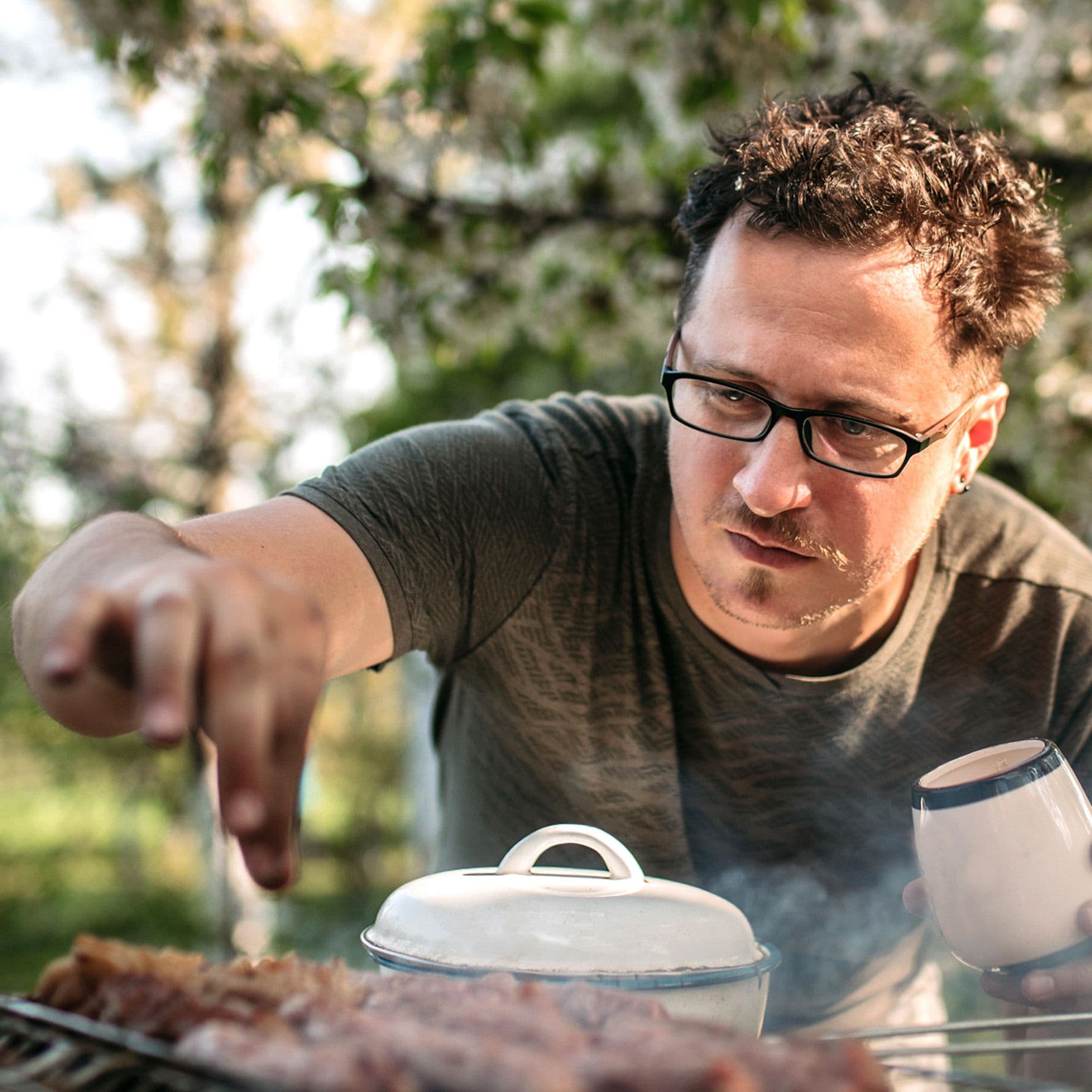 Ein Mann grillt Fleisch und guckt skeptisch