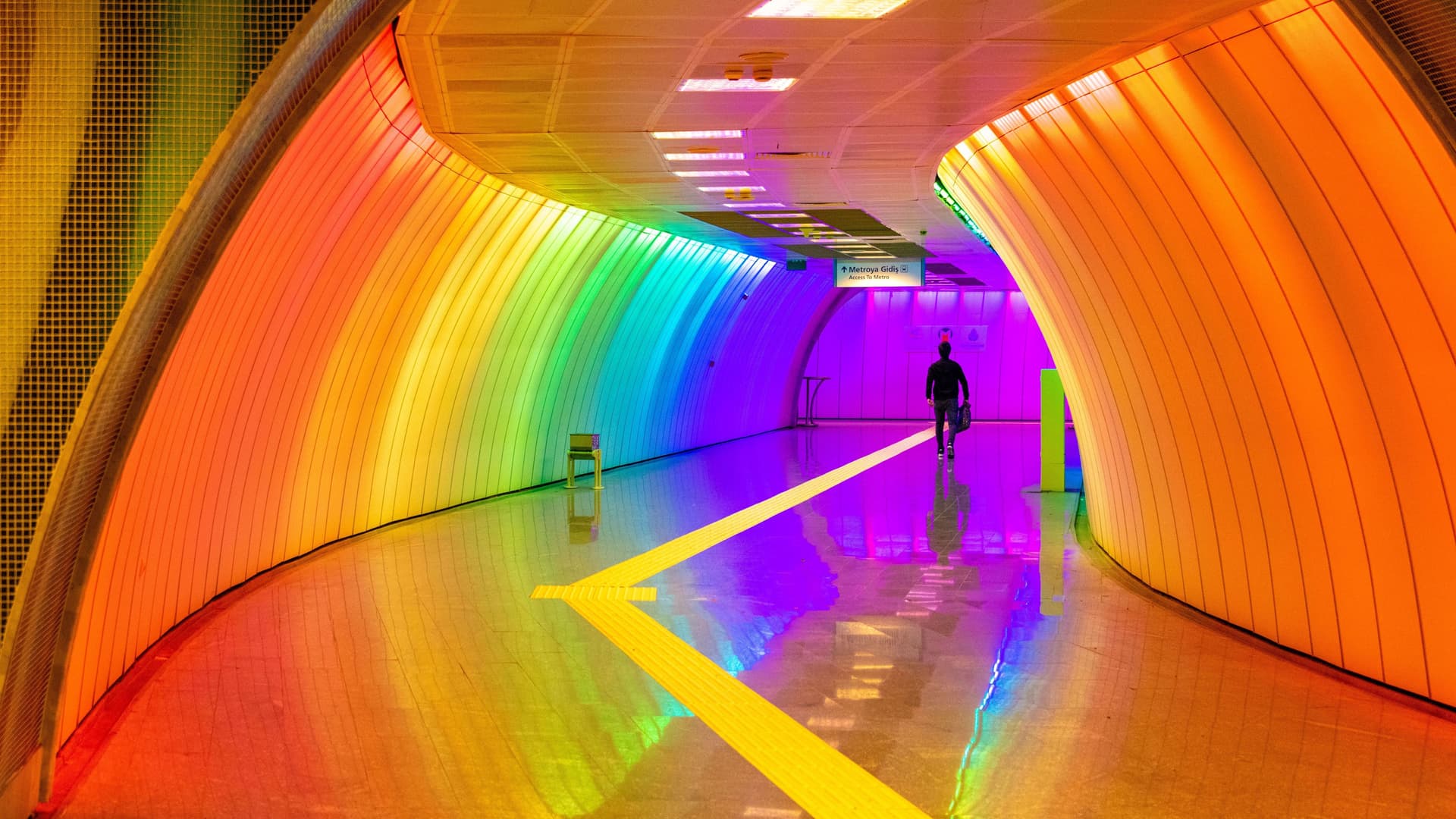 Ein regenbogen-farben beleuchteter Tunnel zur U-Bahn in Istanbul.