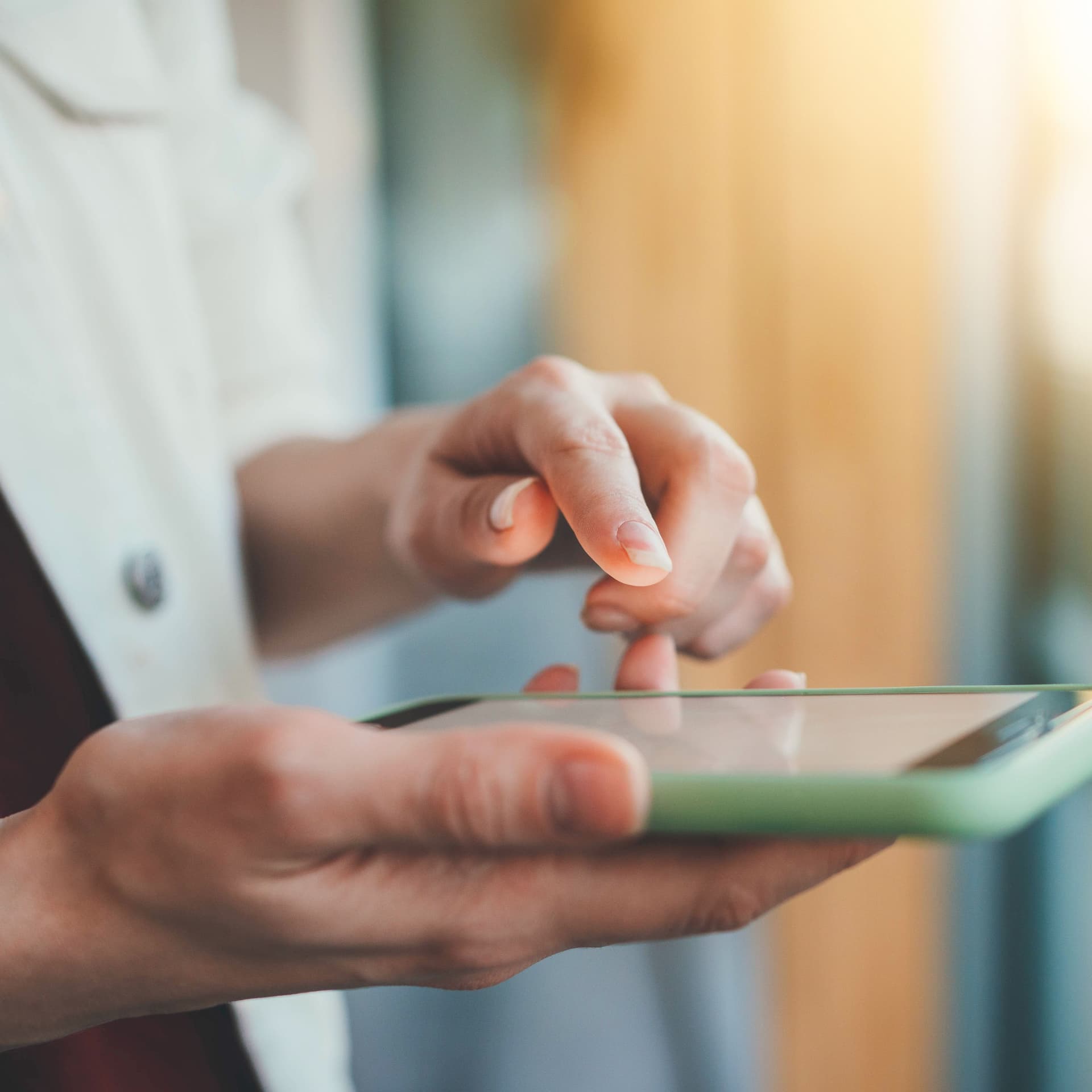 Nahaufnahme einer weiblichen Hand, die auf ein Smartphone tippt.