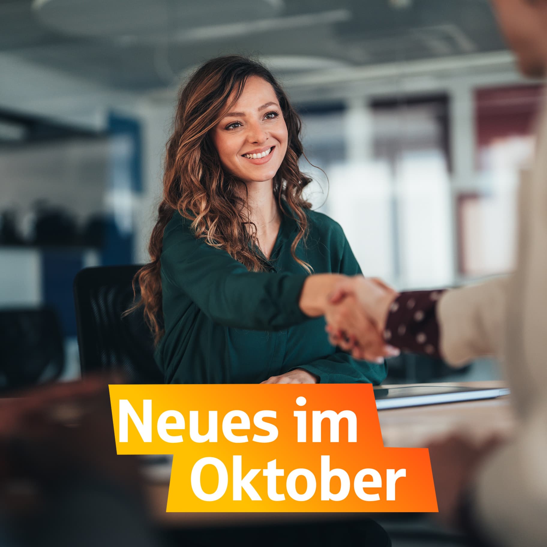 junge lächelnde Frau gibt einer zweiten Person die Hand.