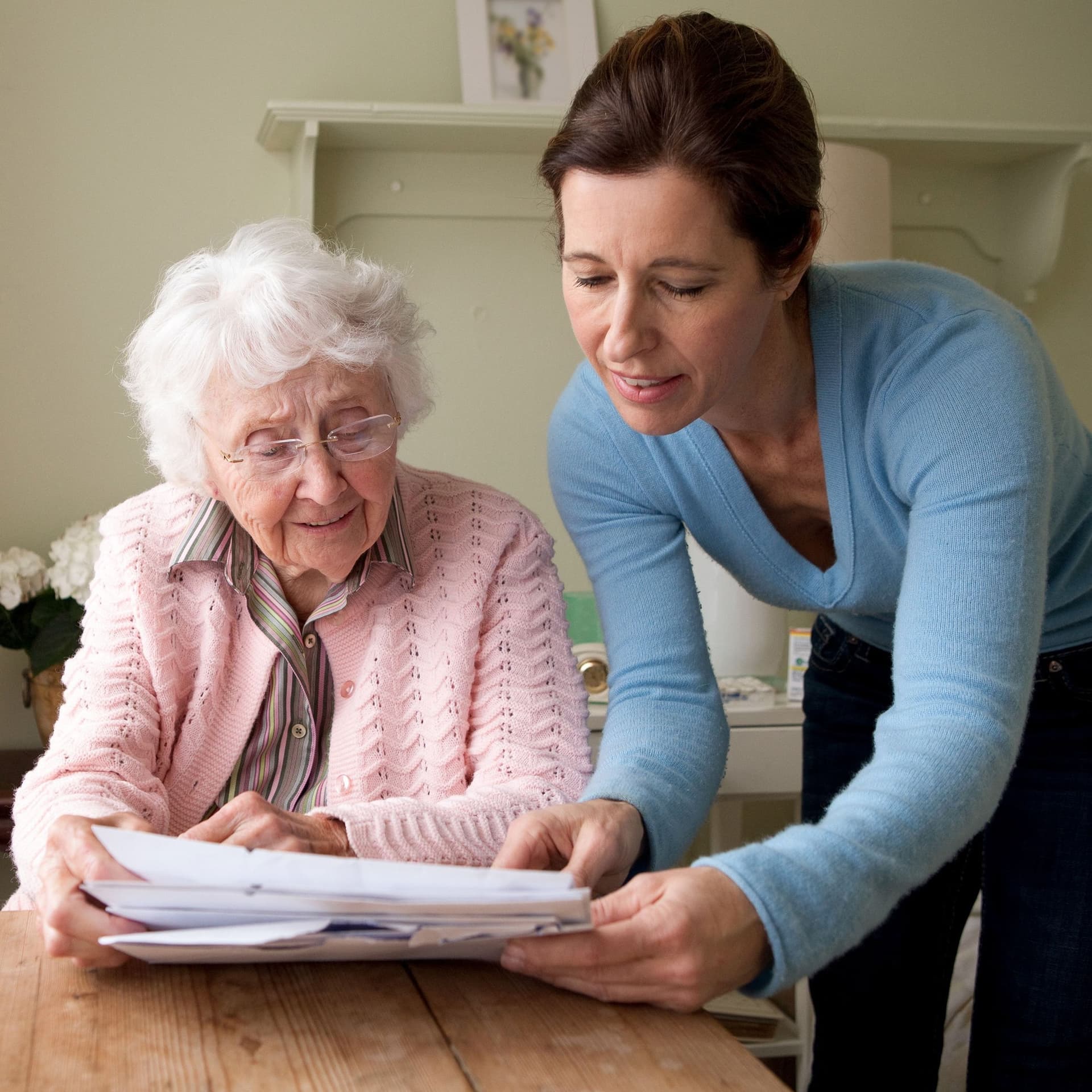 Eine Pflegerin geht mit einer Seniorin Unterlegen durch.