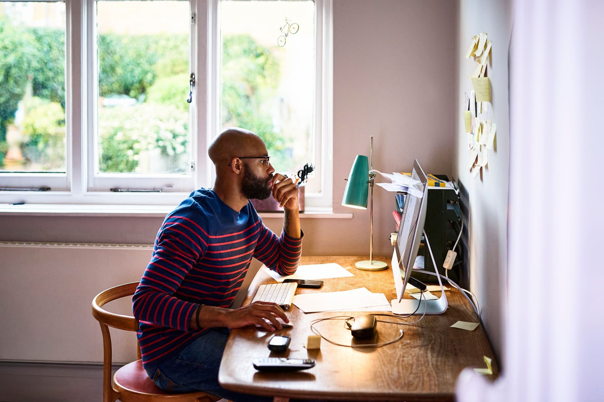 Ein Mann sitzt am Computer in seiner Wohnung. 