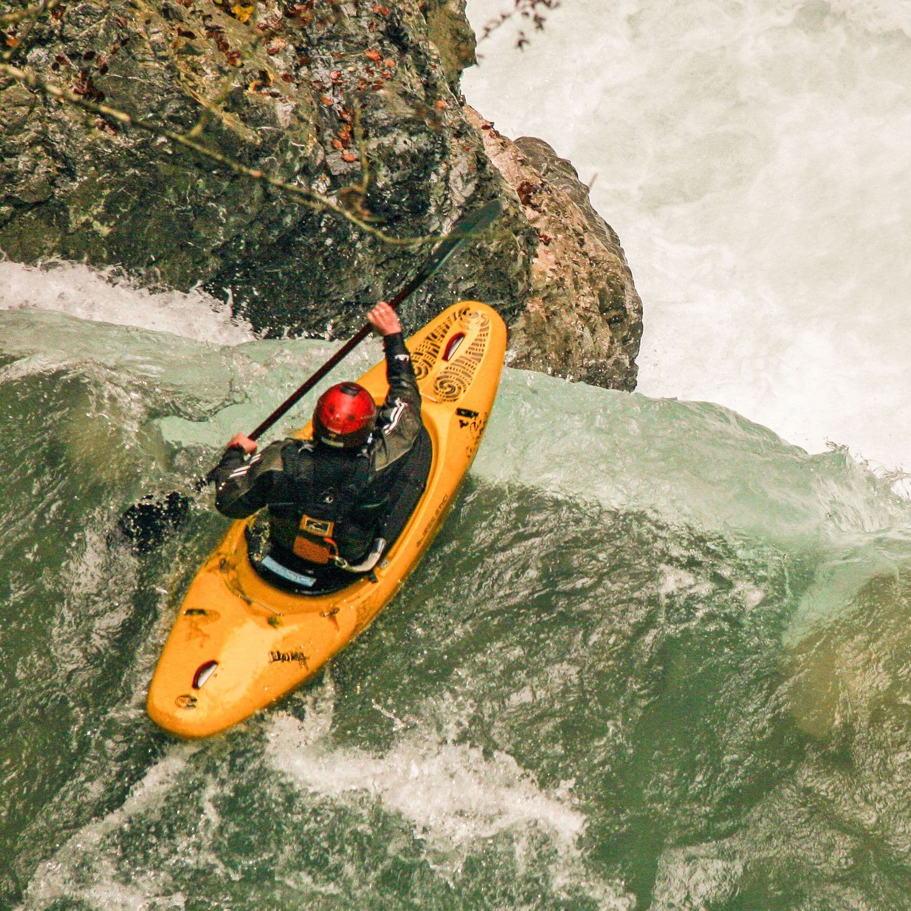 Ein Extremsportler mit Kajak an einem Wasserfall in der Rißbachklamm in Oberbayern.