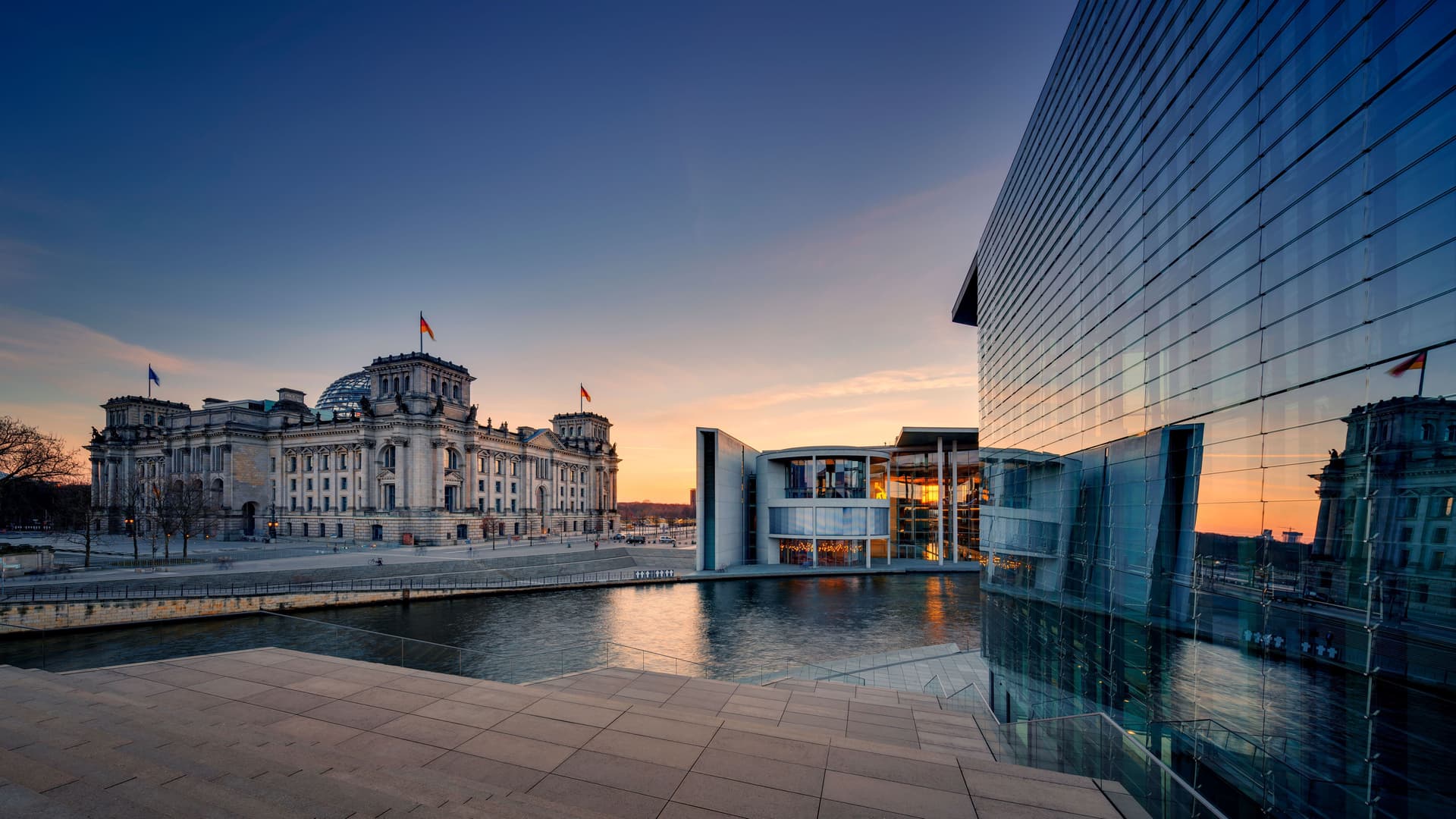 Blick auf den Recihstag mit Spree im Vordergrund und einem Teil des Kanzleramts.