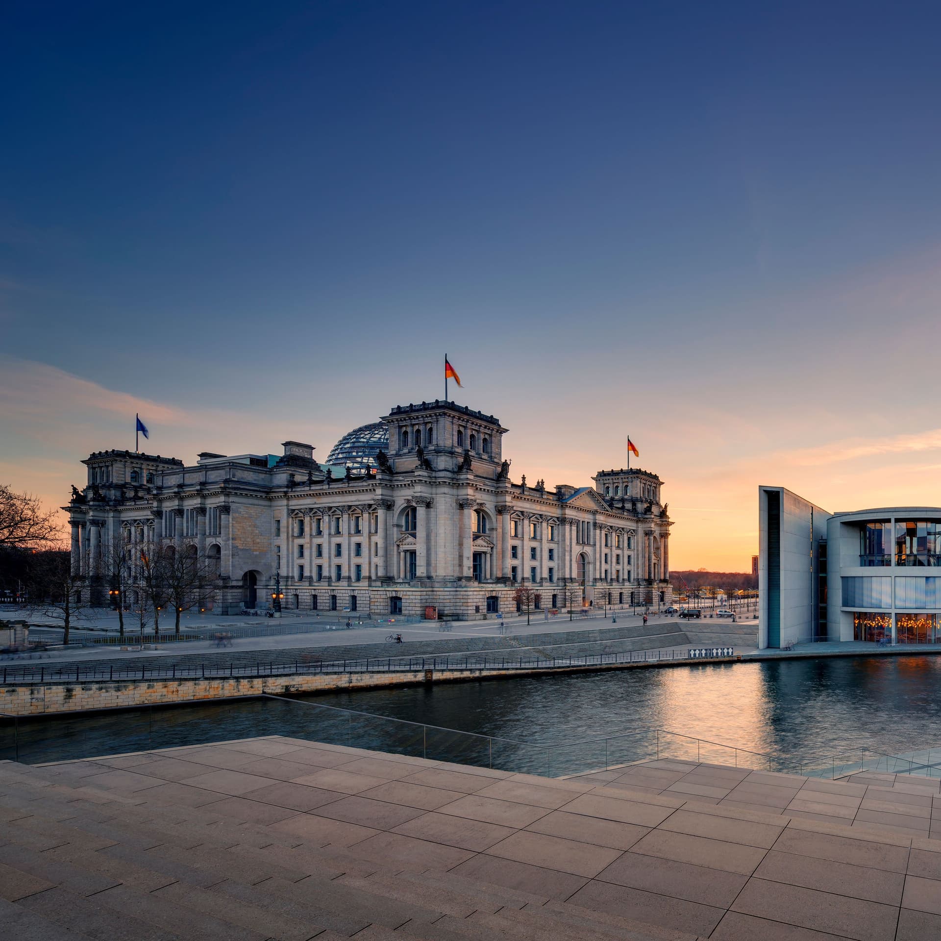 Blick auf den Recihstag mit Spree im Vordergrund und einem Teil des Kanzleramts.