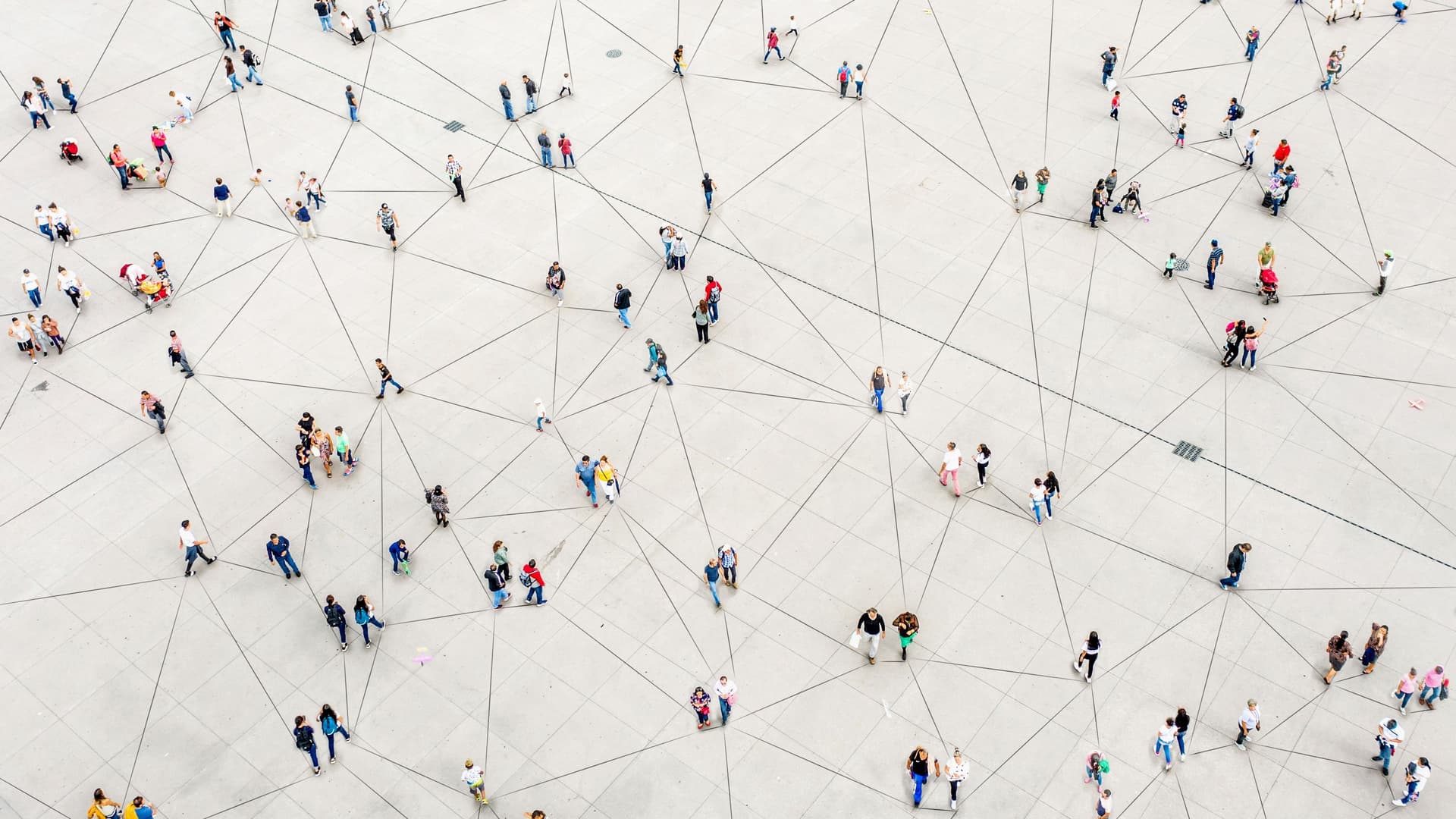 Menschen auf einem Platz aus der Vogelperspektive betrachtet. Zwischen Ihnen befinden sich Verbindungslinien auf dem Boden.