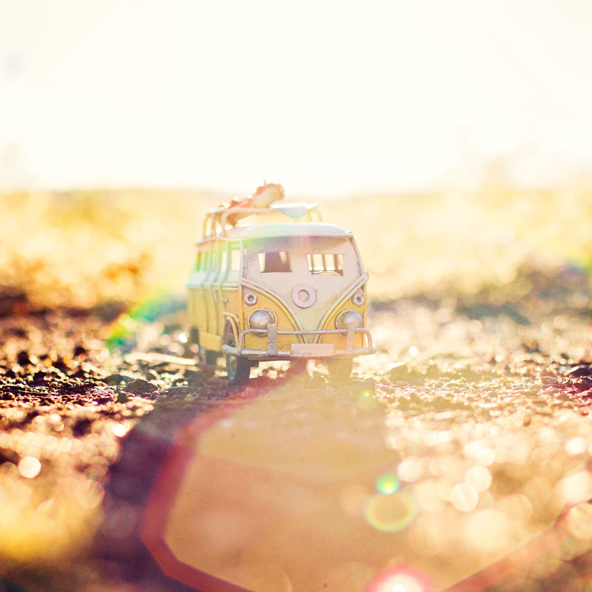 Ein Miniatur VW-Bus steht auf der Erde im strahlenden Sonnenschein.