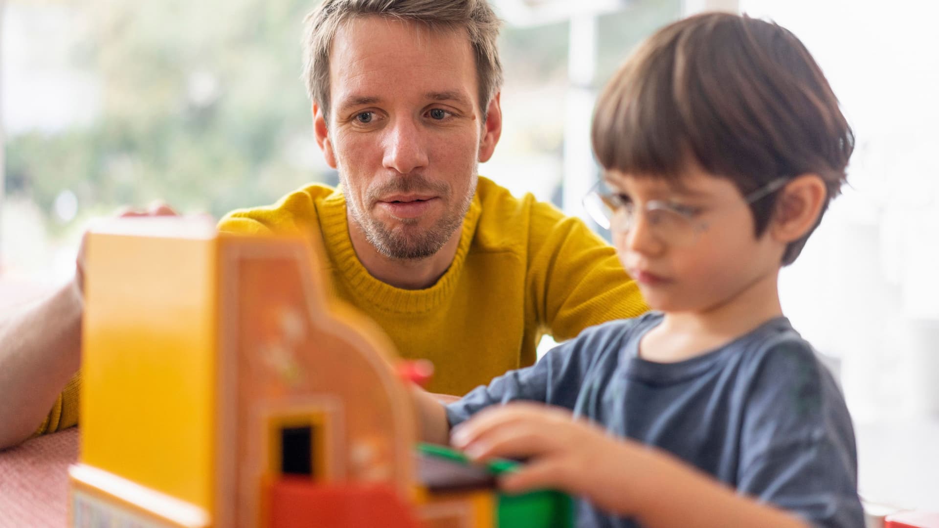 Vater und Sohn spielen mit einer Spielzeugkasse
