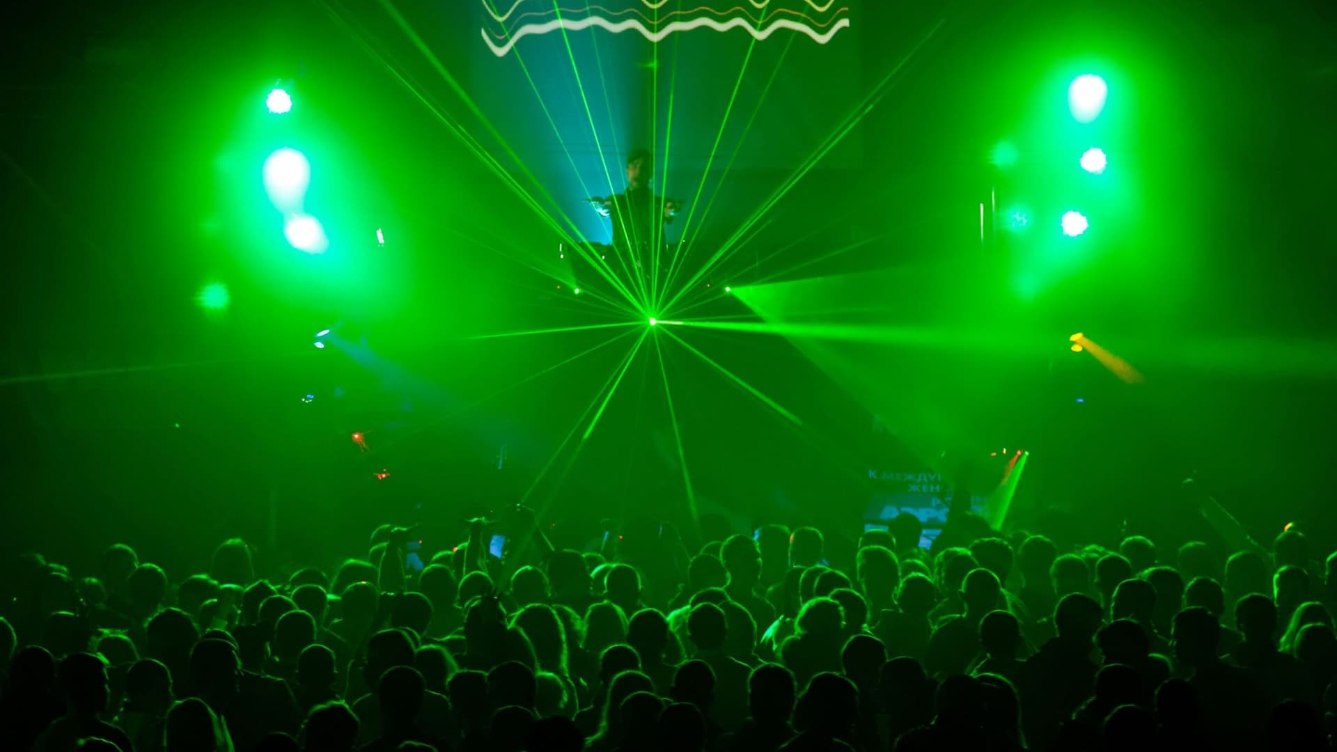 Menschenmenge im Club mit grünem Gegenlicht.