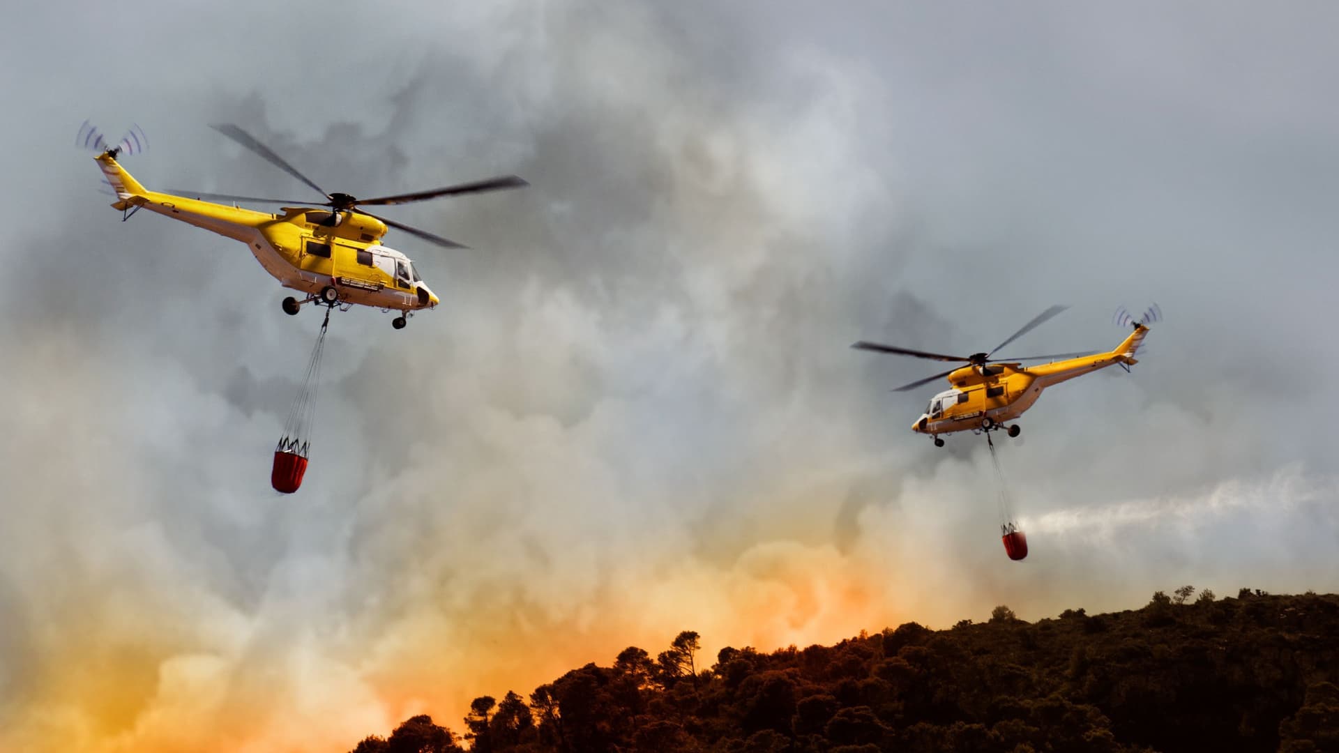 Zwei Hubschrauber bekämpfen einen Waldbrand