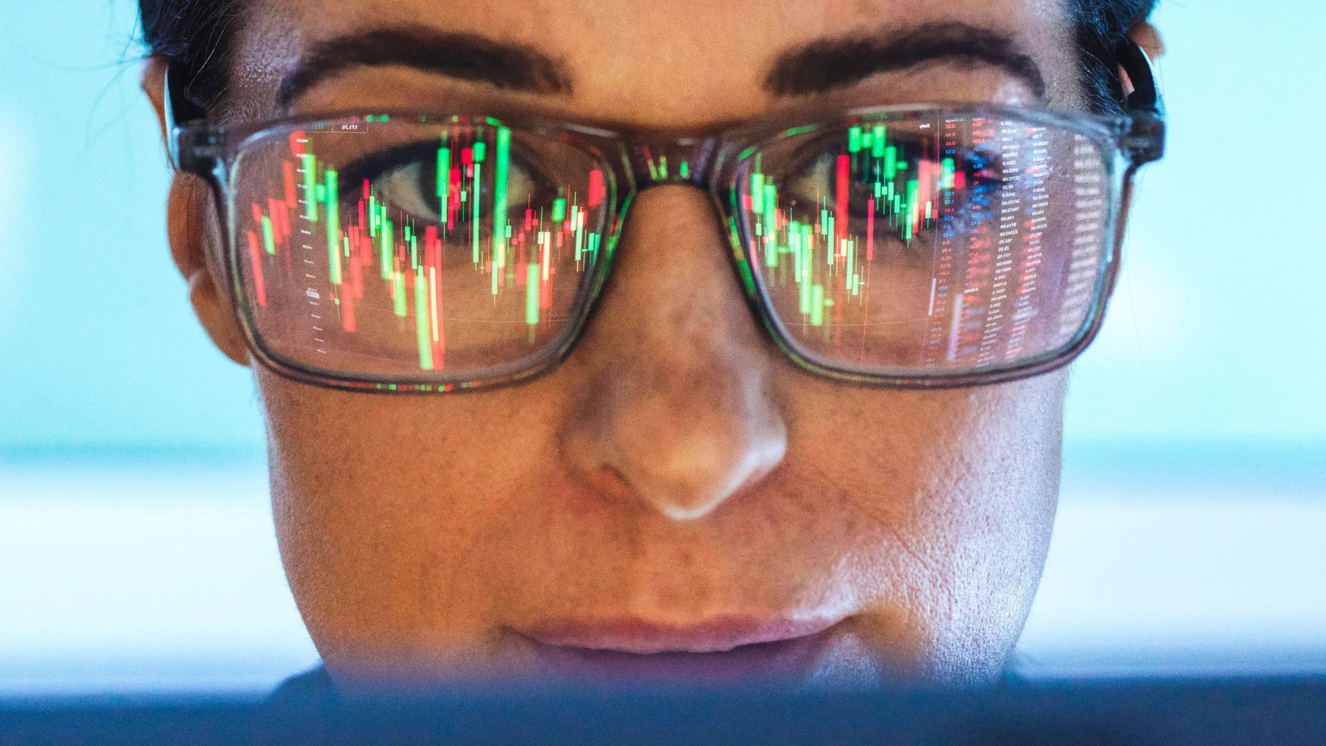 Börsenmakler analysiert den Finanzmarkt mit Bildschirmreflexion auf der Brille