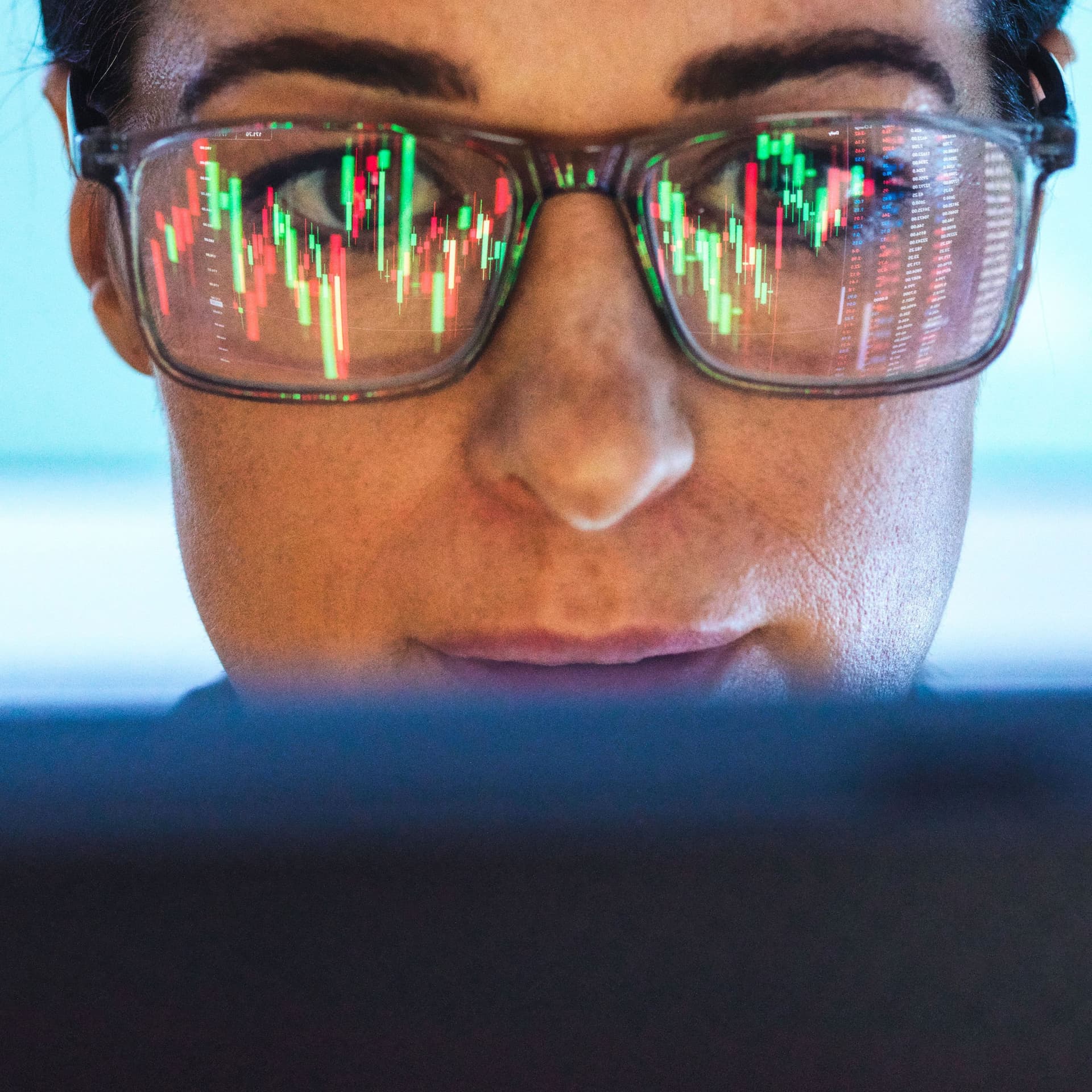 Börsenmakler analysiert den Finanzmarkt mit Bildschirmreflexion auf der Brille