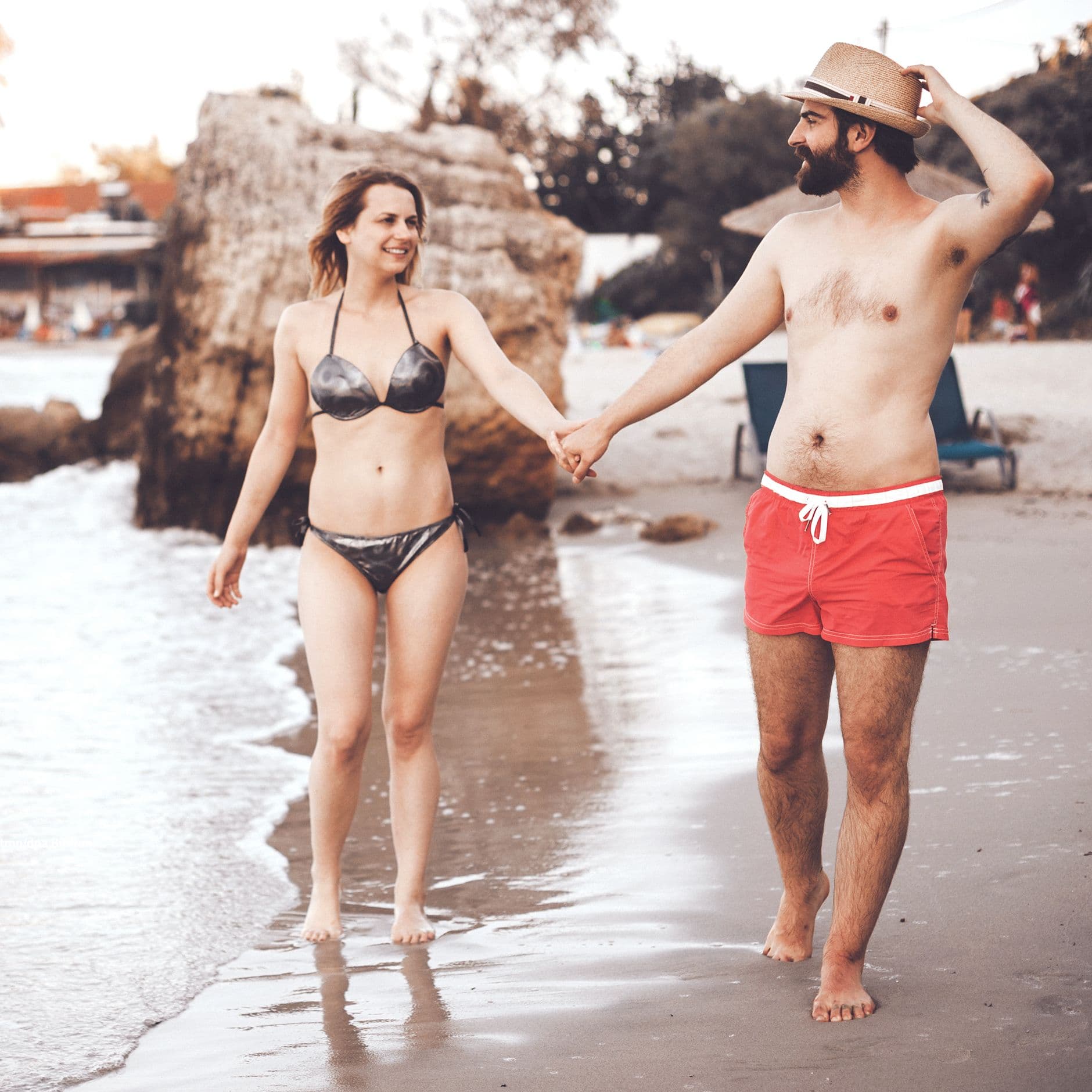 Frau und Mann laufen in Badesachen am Strand