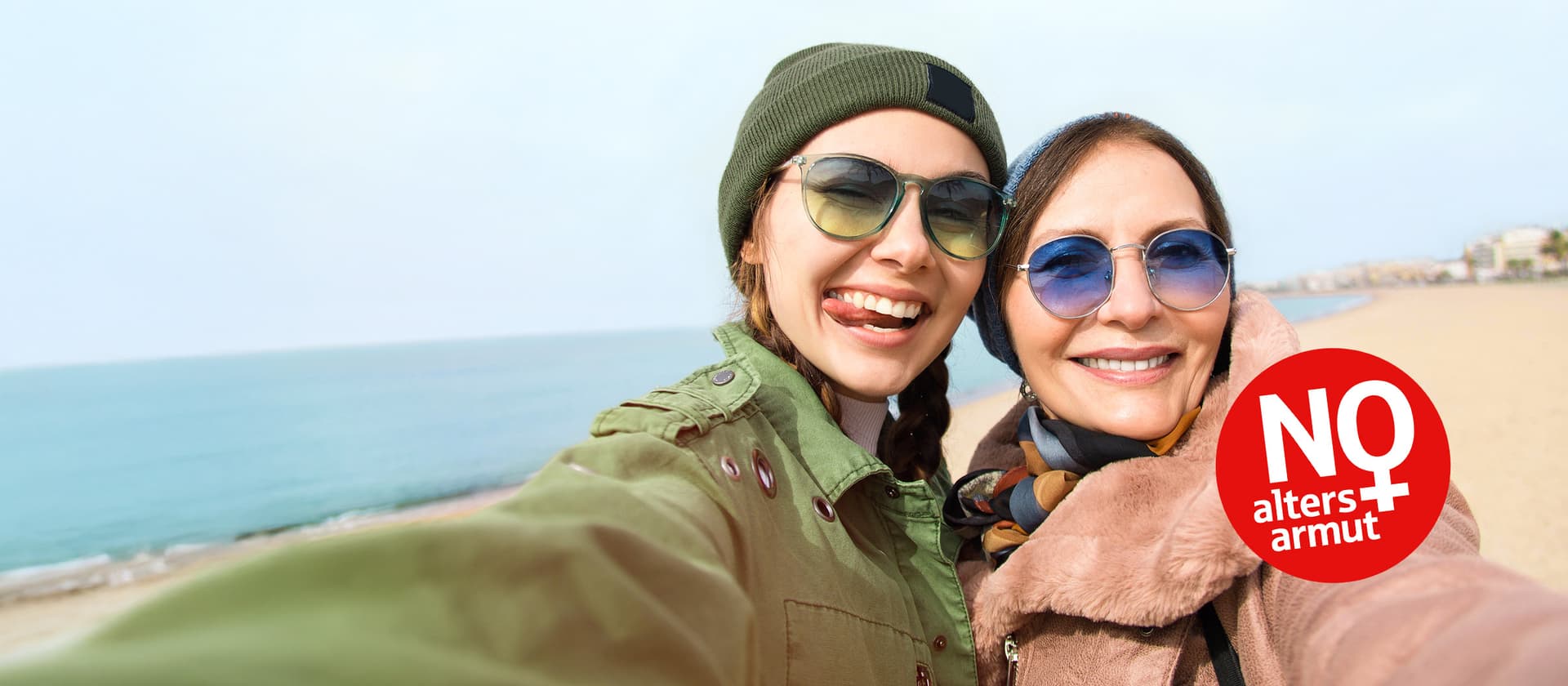 Zwei Frauen am Strand lächeln in die Kamera. Ein Symbol fordert: „Keine Altersarmut für Frauen“.