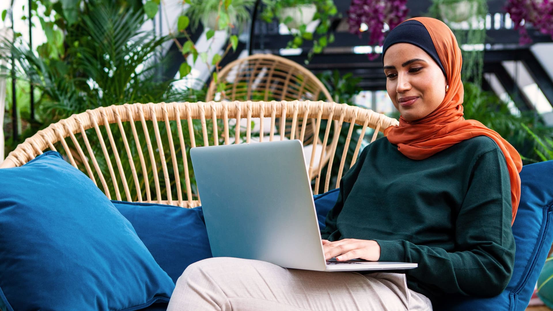 Frau mit Kopftuch mit Laptop zu Hause