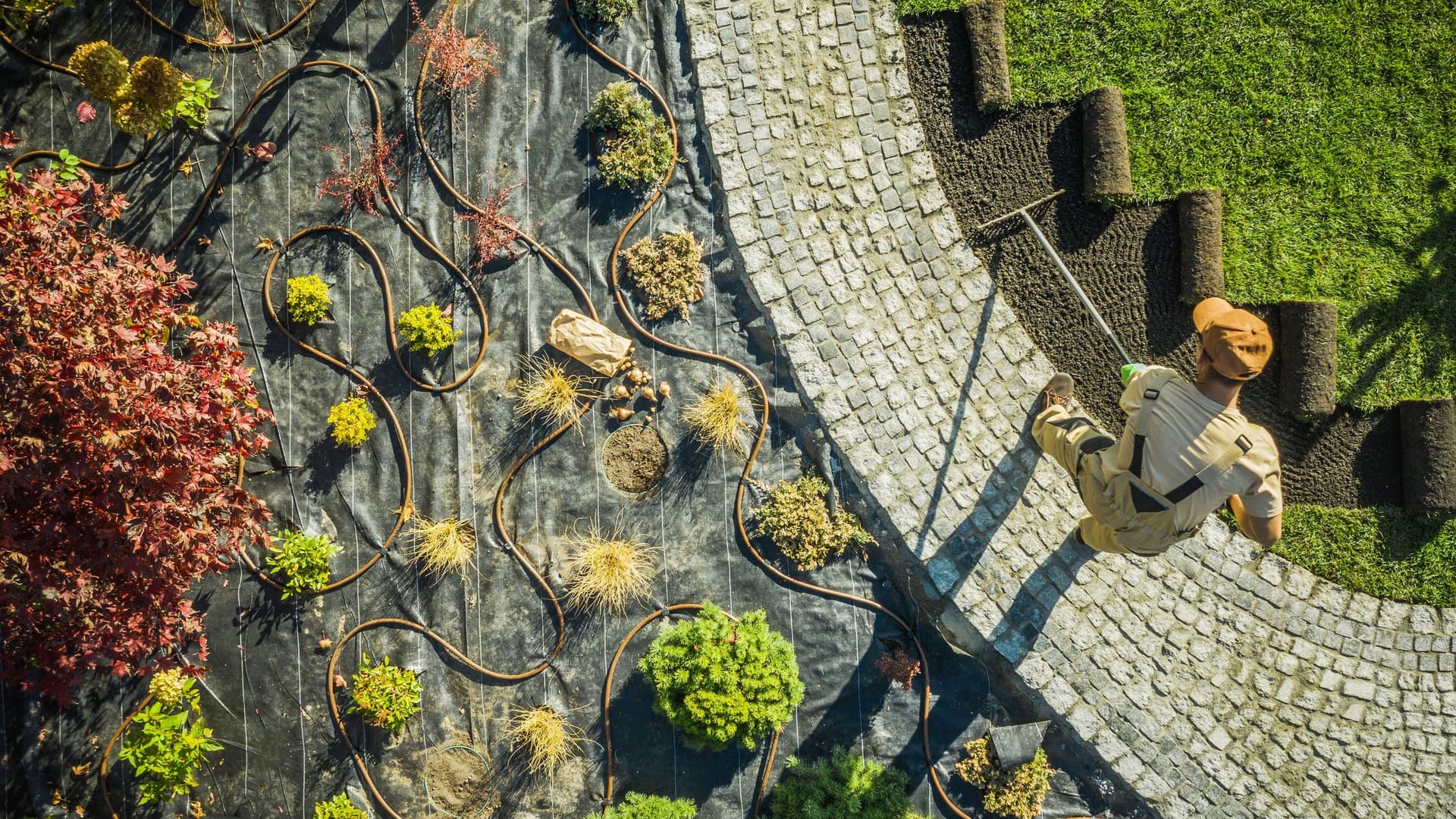 Ein Gärtner legt einen Garten an. Sicht aus der Vogelperspektive.