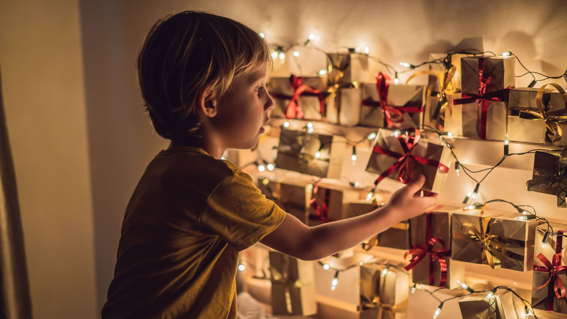 The boy opens a gift from the advent calendar