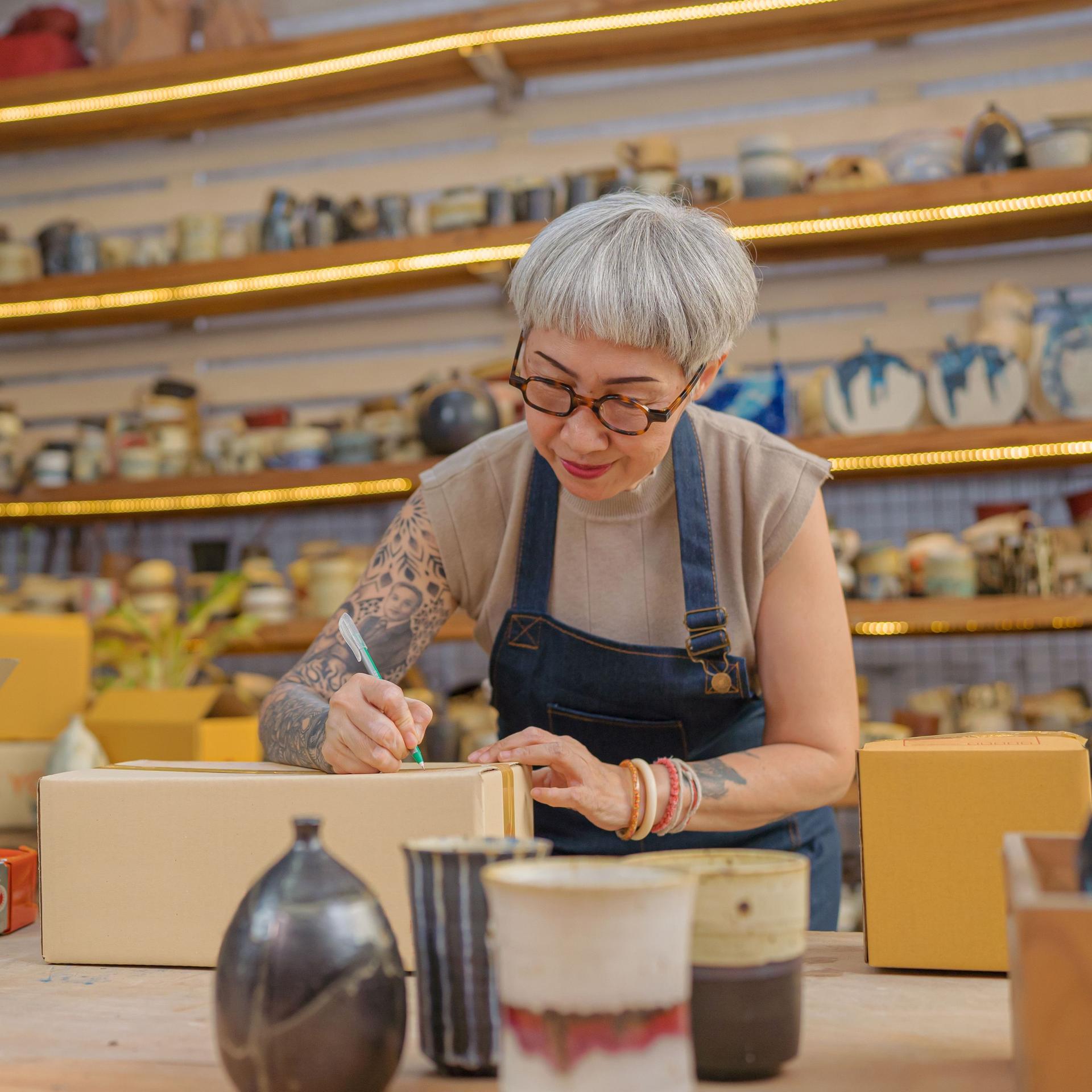 Eine Künstlerin verpackt Keramik-Produkte in ihrem Atelier.