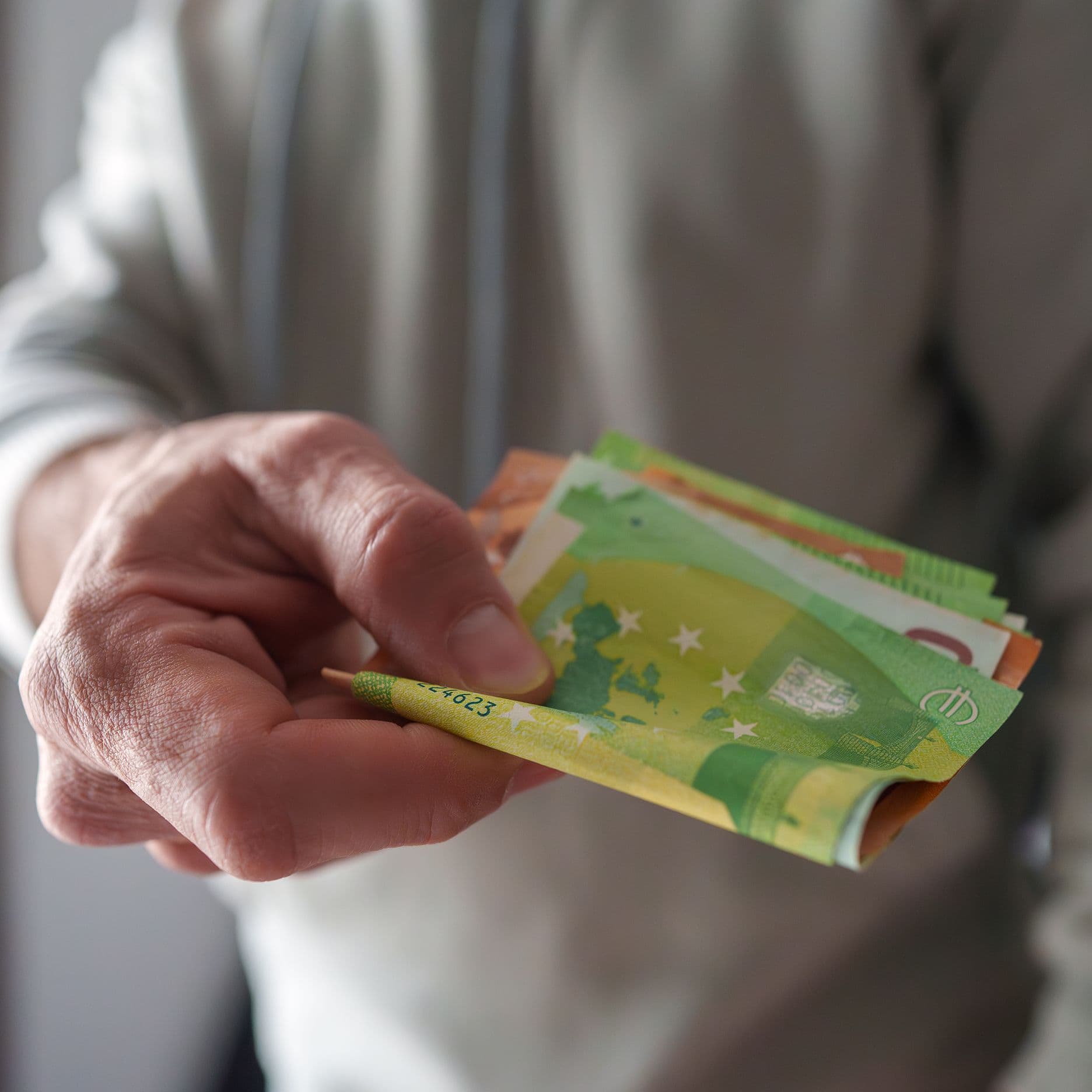 eine-hand-reicht-geld-an-eine-person-GI-2196557533-4000kb-original
