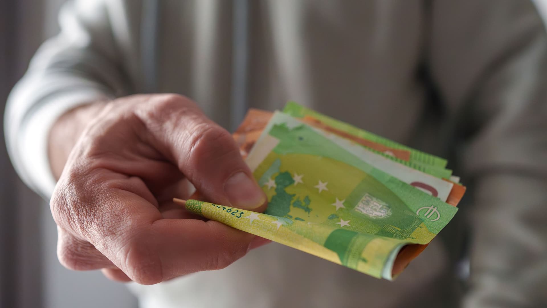 eine-hand-reicht-geld-an-eine-person-GI-2196557533-4000kb-original