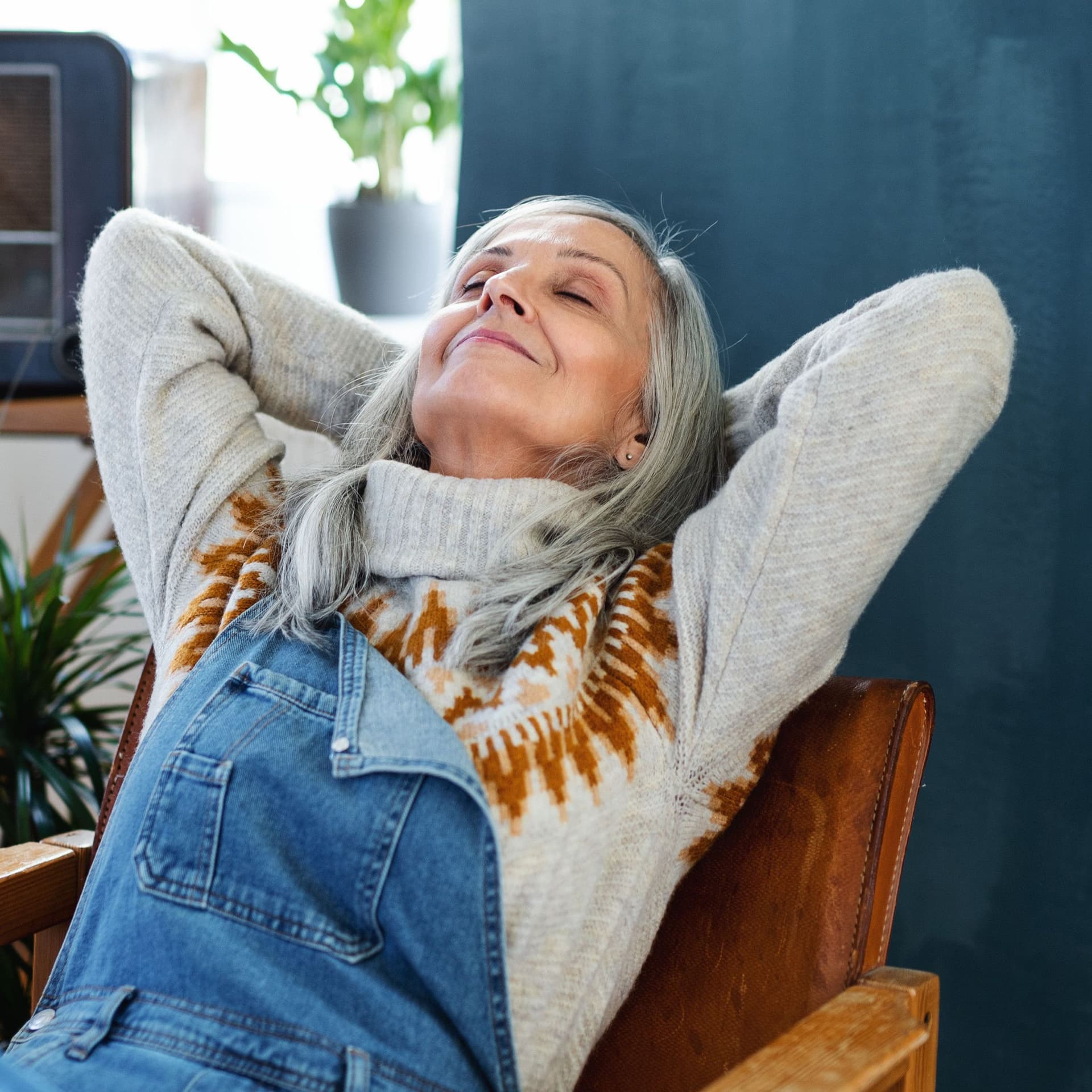 Senior woman sitting indoors at home, relaxing.