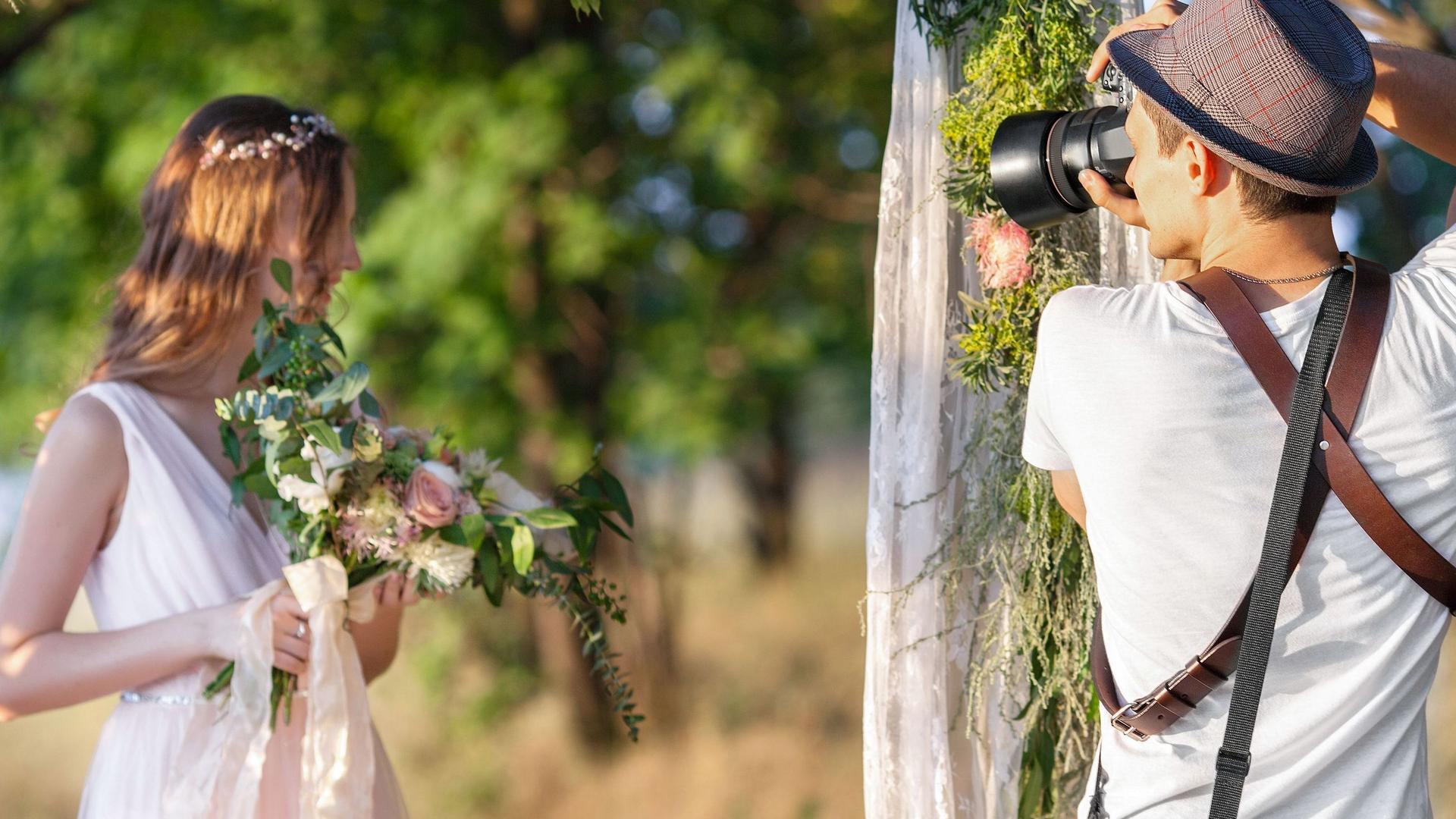 Hochzeitsfotograf macht Portraitaufnahmen der Braut im Freien