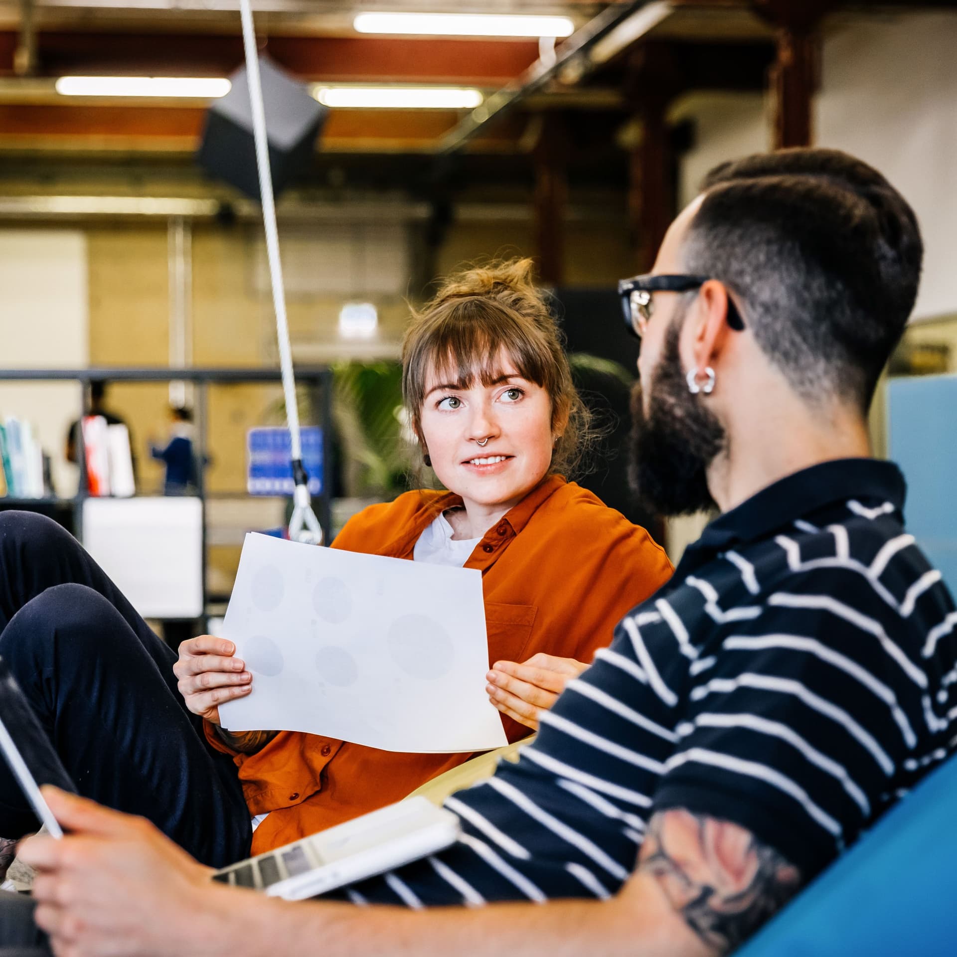 Zwei junge lässige Geschäftsleute bei einem informellen Treffen auf einer großen Schaukel